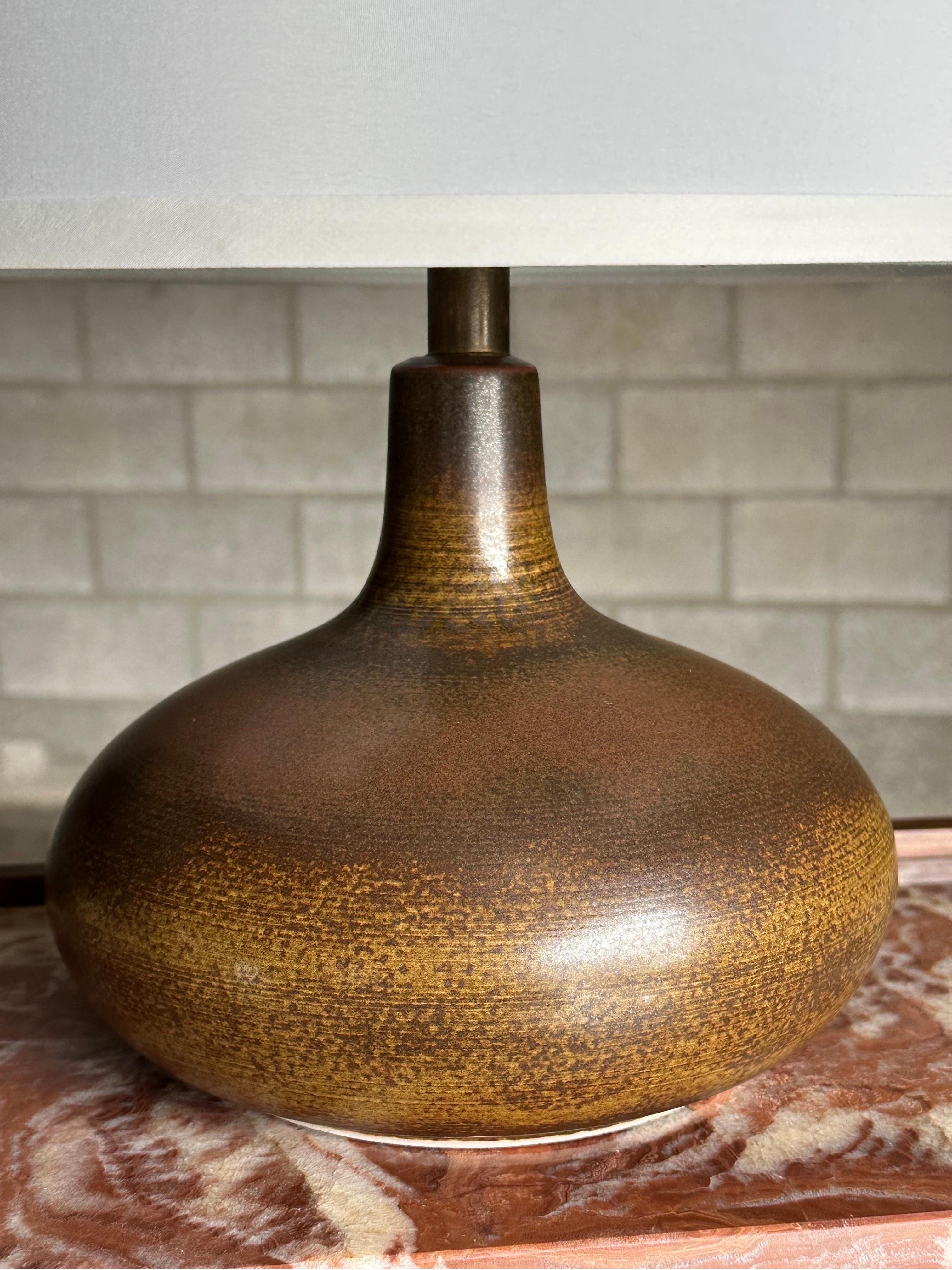 Large table lamp by Lotte and Gunnar Bostlund. While produced in Canada and the US, the ceramicist duo were from Denmark. Very interesting glaze presenting as largely brown with traces of yellow and green.

Dimensions:
Overall 18