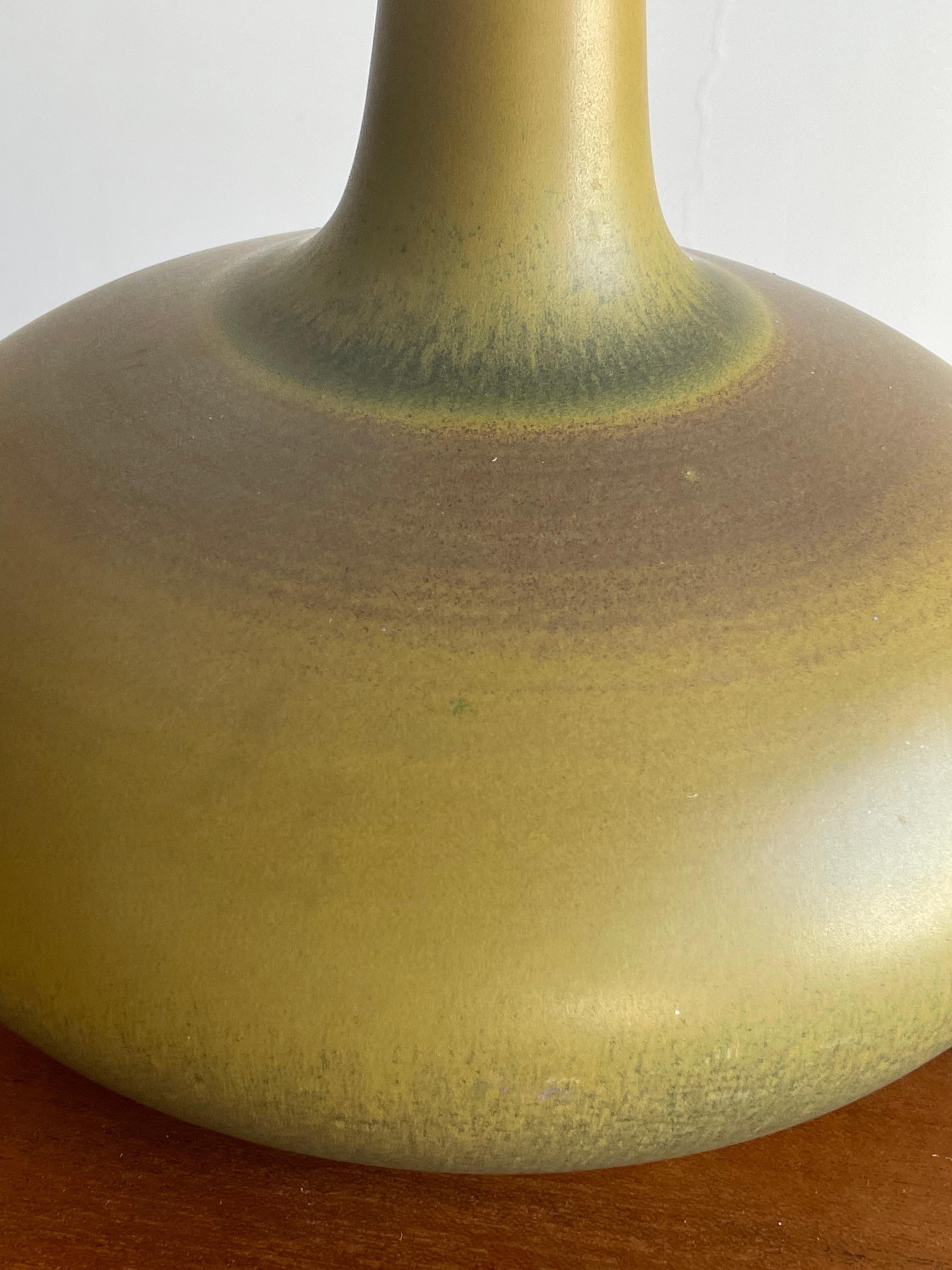 Large table lamp by Lotte and Gunnar Bostlund. While produced in Canada and the US, the ceramicist duo were from Denmark. This is an unusual and welcomed color/ glaze as it has tremendous movement in the color.

Measures: 17” tall overall
13”