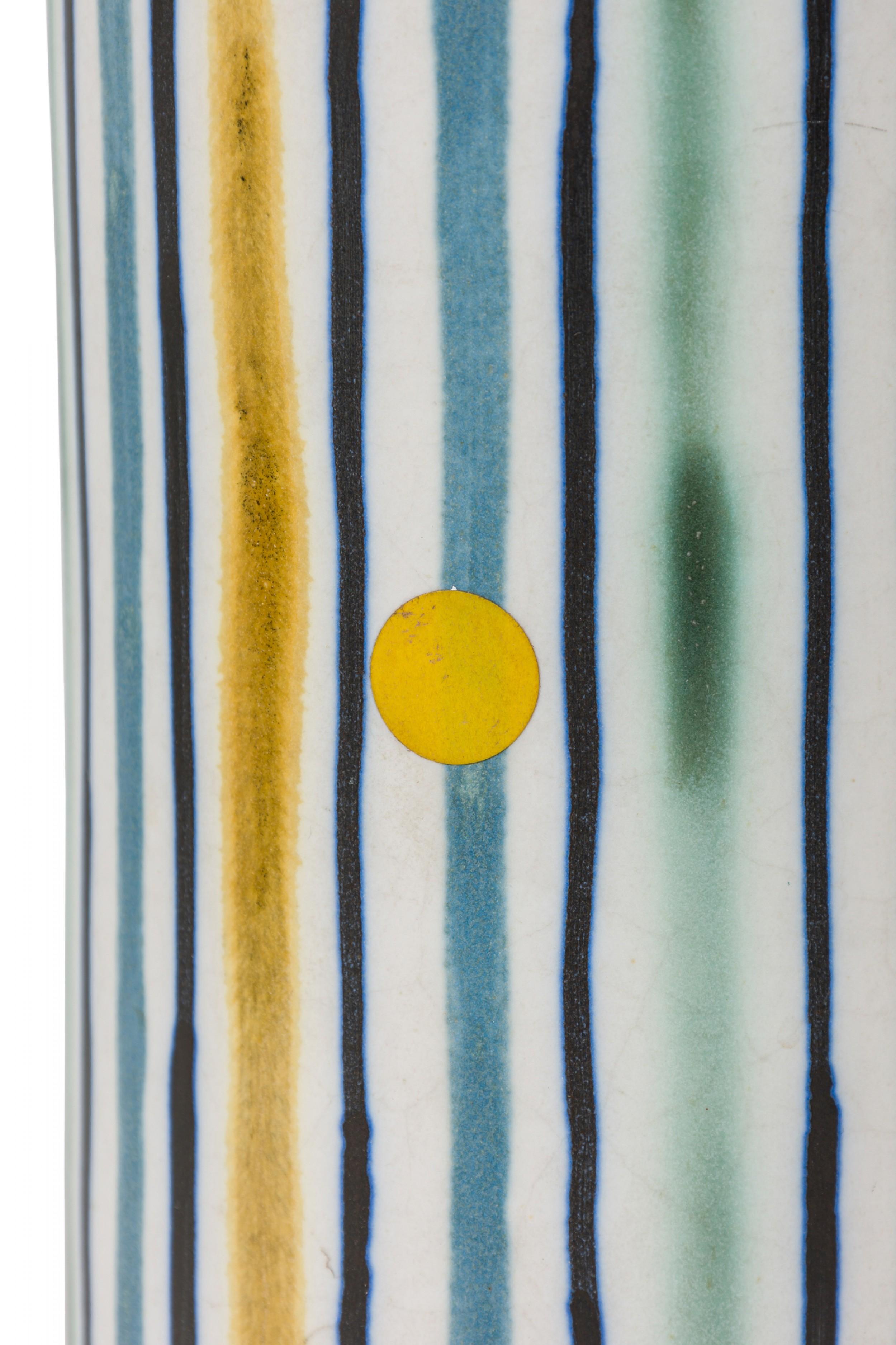 Mid-Century Danish ceramic table lamp (Model no. 302) in tall cylindrical form with tapered neck leading to an extended functioning brass light switch socket, the body glazed in a matte finish with hand painted blue, brown, yellow and white vertical