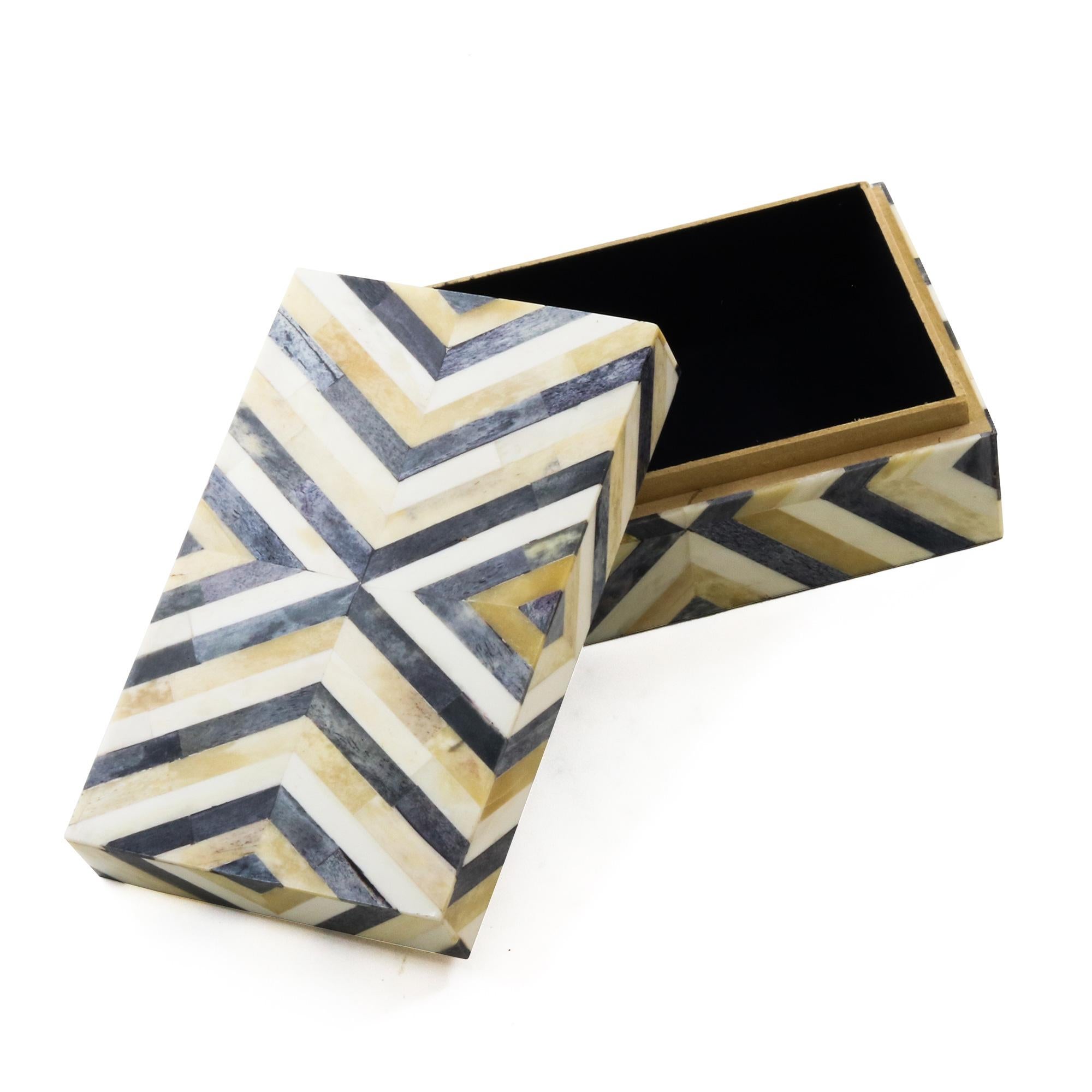 An ivory and brown decorative bone box. Features an all over playful triangular pattern.
     