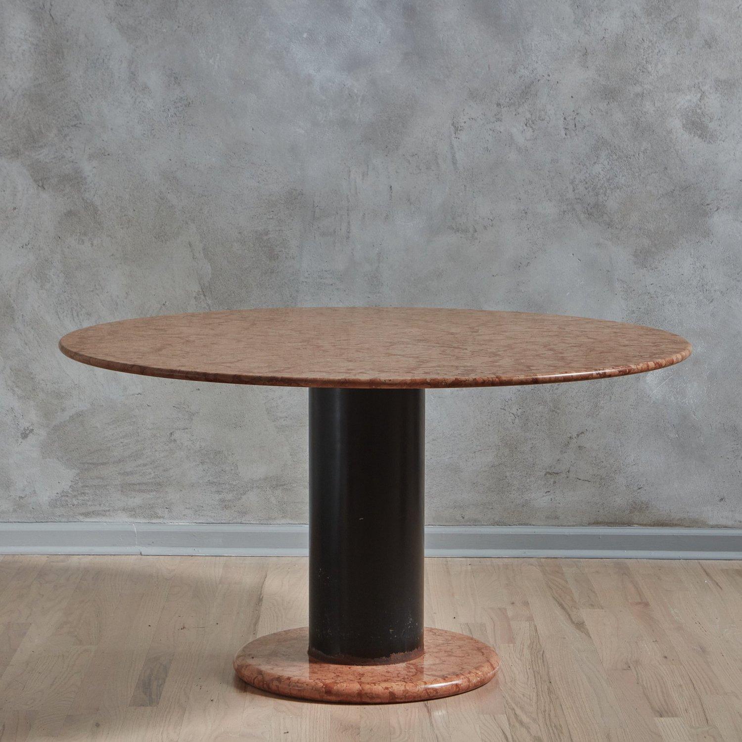 A Mid Century Italian dining table attributed to Ettore Sottsass for Poltronova, 1965. This table features a circular Lotto Rosso marble tabletop with a beveled edge and gorgeous coral and salmon veining. It has a matching circular base and a