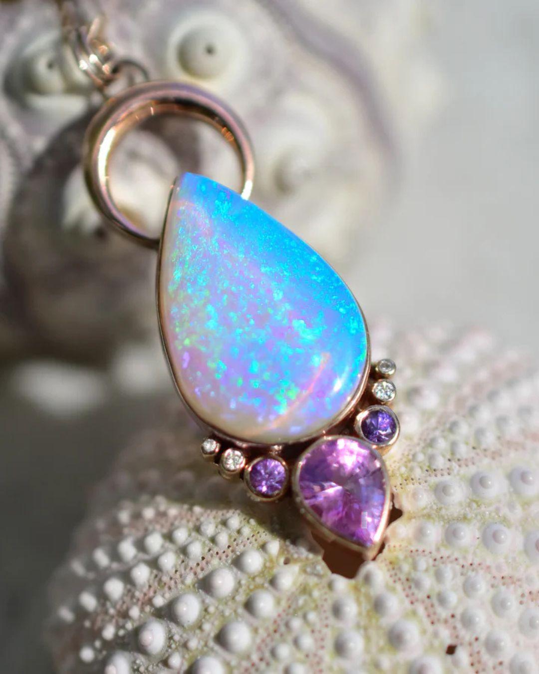 Ciondolo a forma di bocciolo di loto con luna di fuoco color lavanda e acqua, zaffiri e diamanti in oro rosa massiccio 14k. Lunghezza 42 mm. 

La catena è venduta separatamente, ma quella nelle foto può essere acquistata o posso ordinarne una di