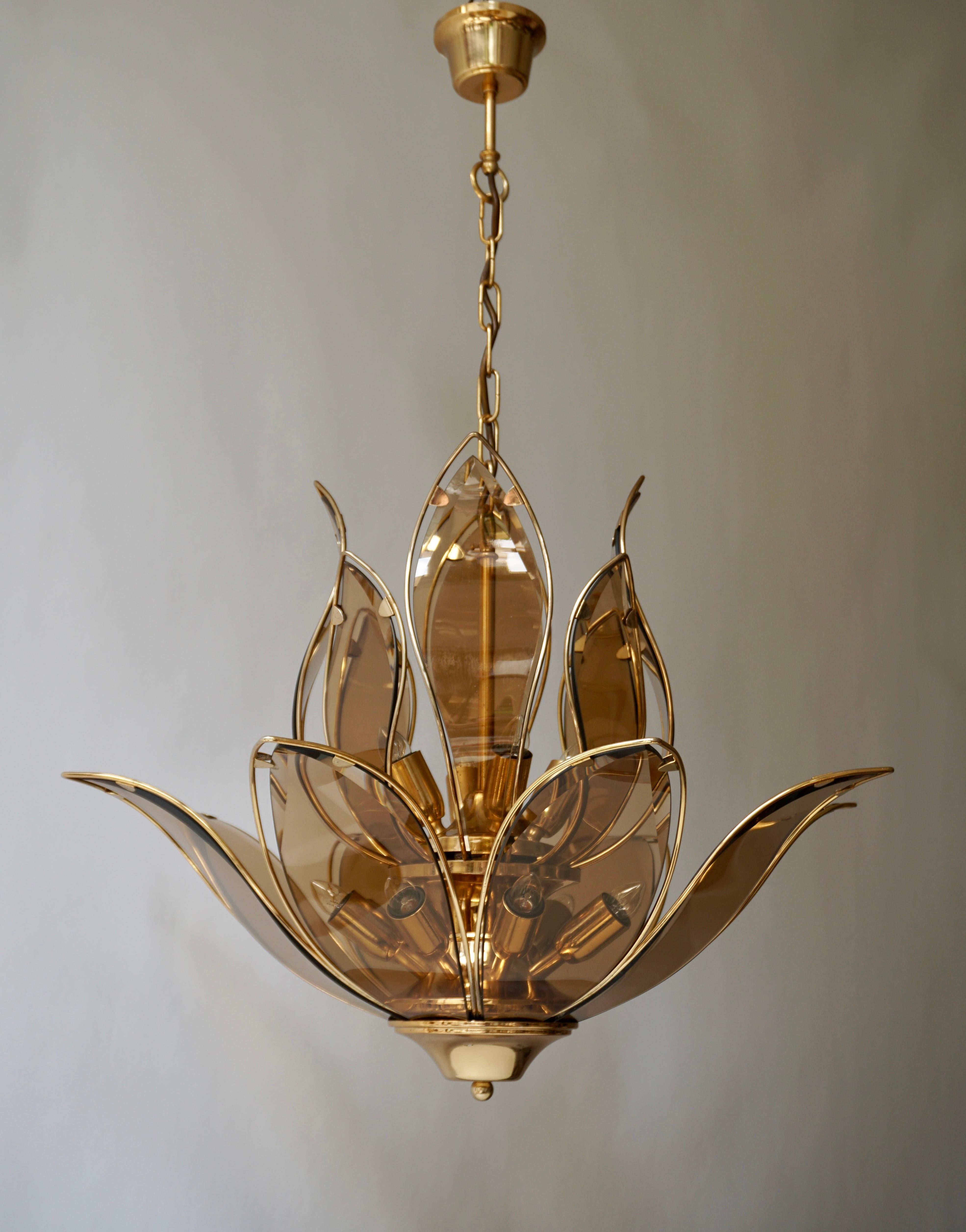 Three outstanding and highly elegant brass and Murano glass chandelier in lotus flower shape of very good quality. This chandelier dates from the 1970s and is Italian by origin. 

The light requires twelve single E14 screw fit lightbulbs (60Watt