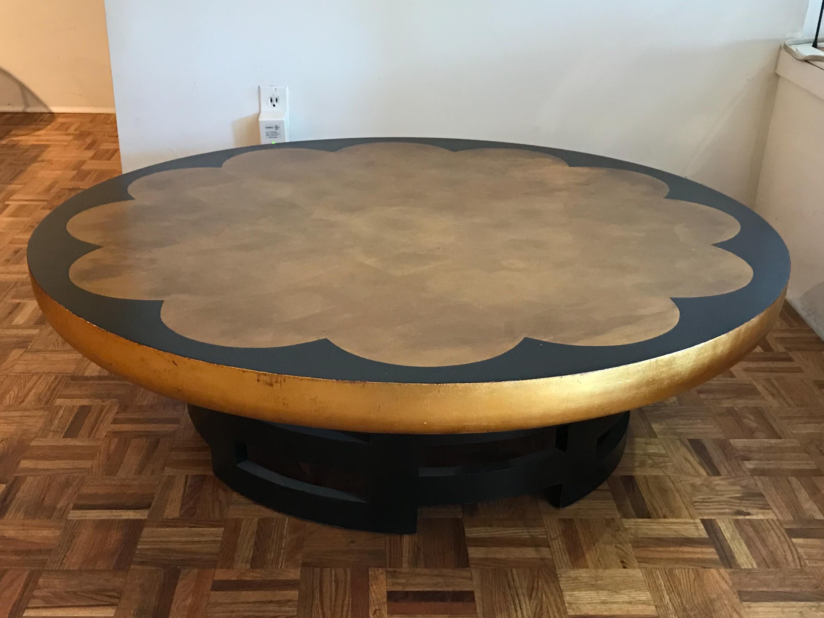 Lotus coffee table by Theodore Muller and Isabelle Barringer for Kittinger Furniture. Gold leaf floral medallion with gold leaf outer edge on ebonized plinth. Good vintage condition with small repair to gold leaf finish on top.
