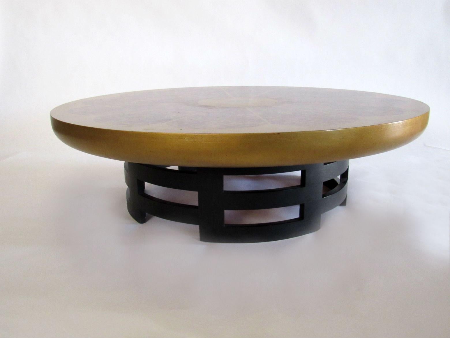 Lotus coffee table designed by Theodore Muller and Isabel Barringer for Kittinger in the 1950s. A large round gilt coffee table on an interlocking, geometric, ebonized-wood base.