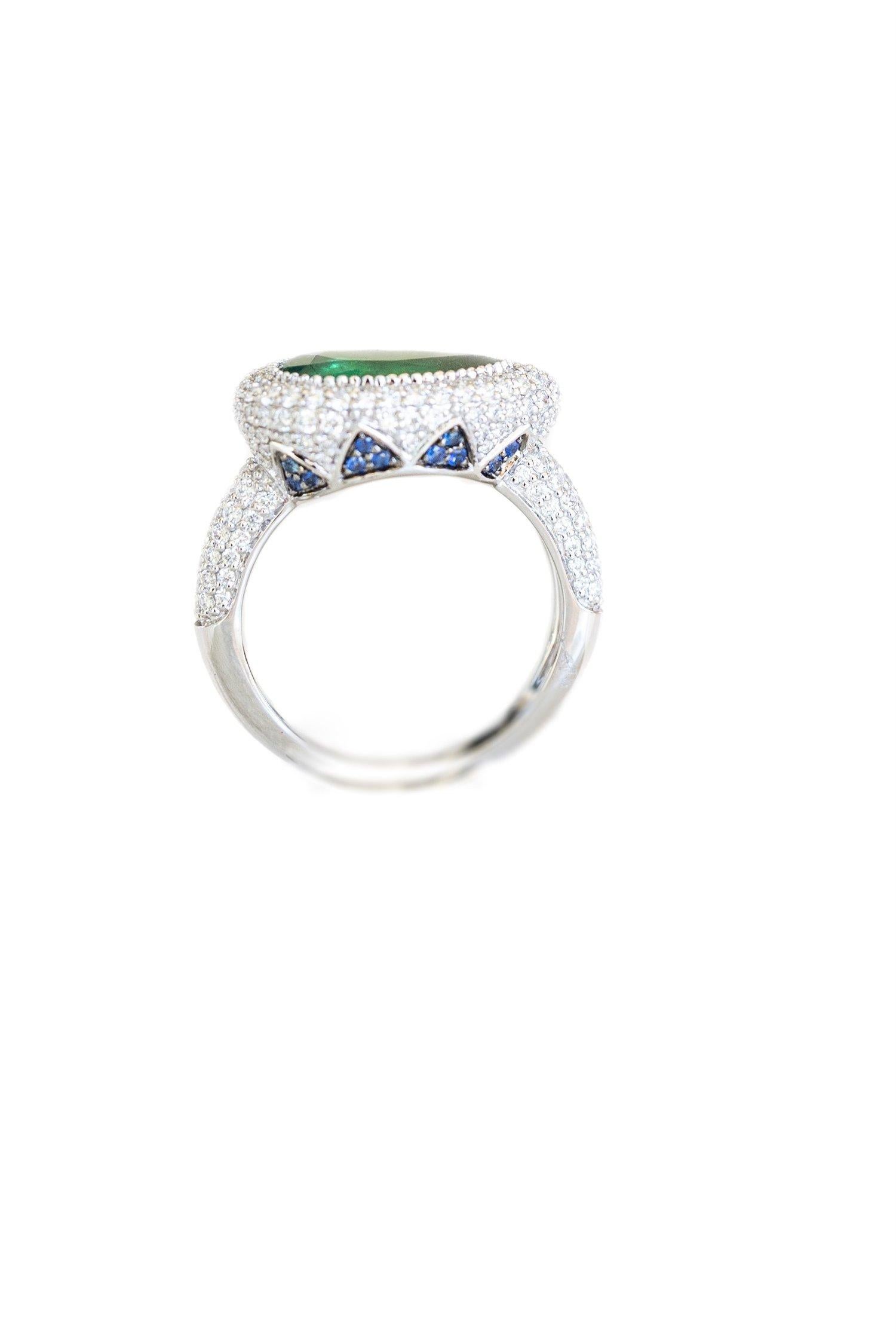18k White Gold. These any-finger rings include a dazzling pear shaped emerald solitaire of approximately 2.25 cts, pave set blue sapphire petals in a lotus motif and pave set brilliant cut white diamonds. Rinoor's re-imagined rings, are incredibly