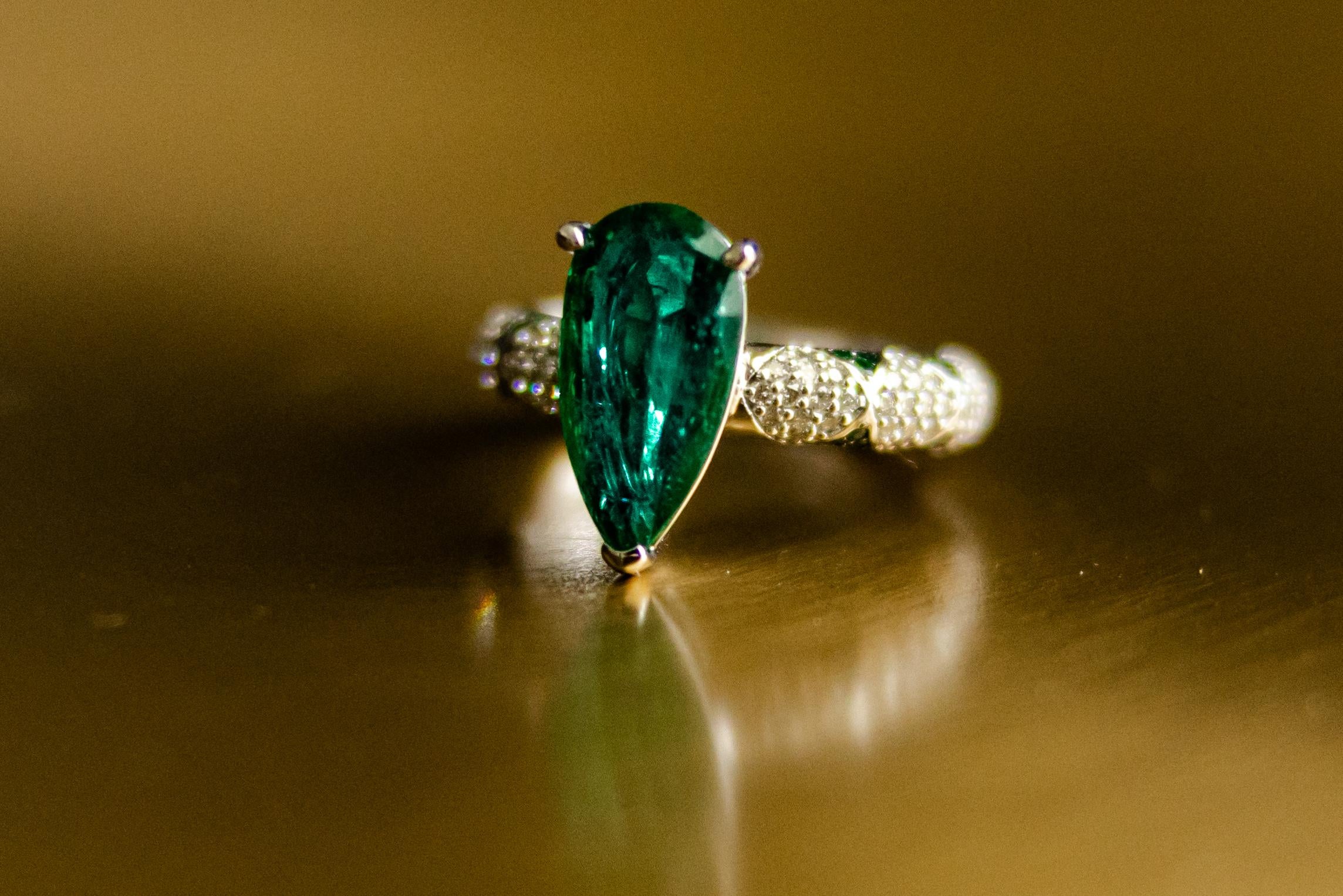 ONE OF A KIND Significant emerald cut Emerald solitaire set in Ri Noor’s iconic lotus motif rings. This statement ring features an emerald solitaire set with emerald petals in a lotus motif and pave set brilliant cut diamonds. Wear it alone as an