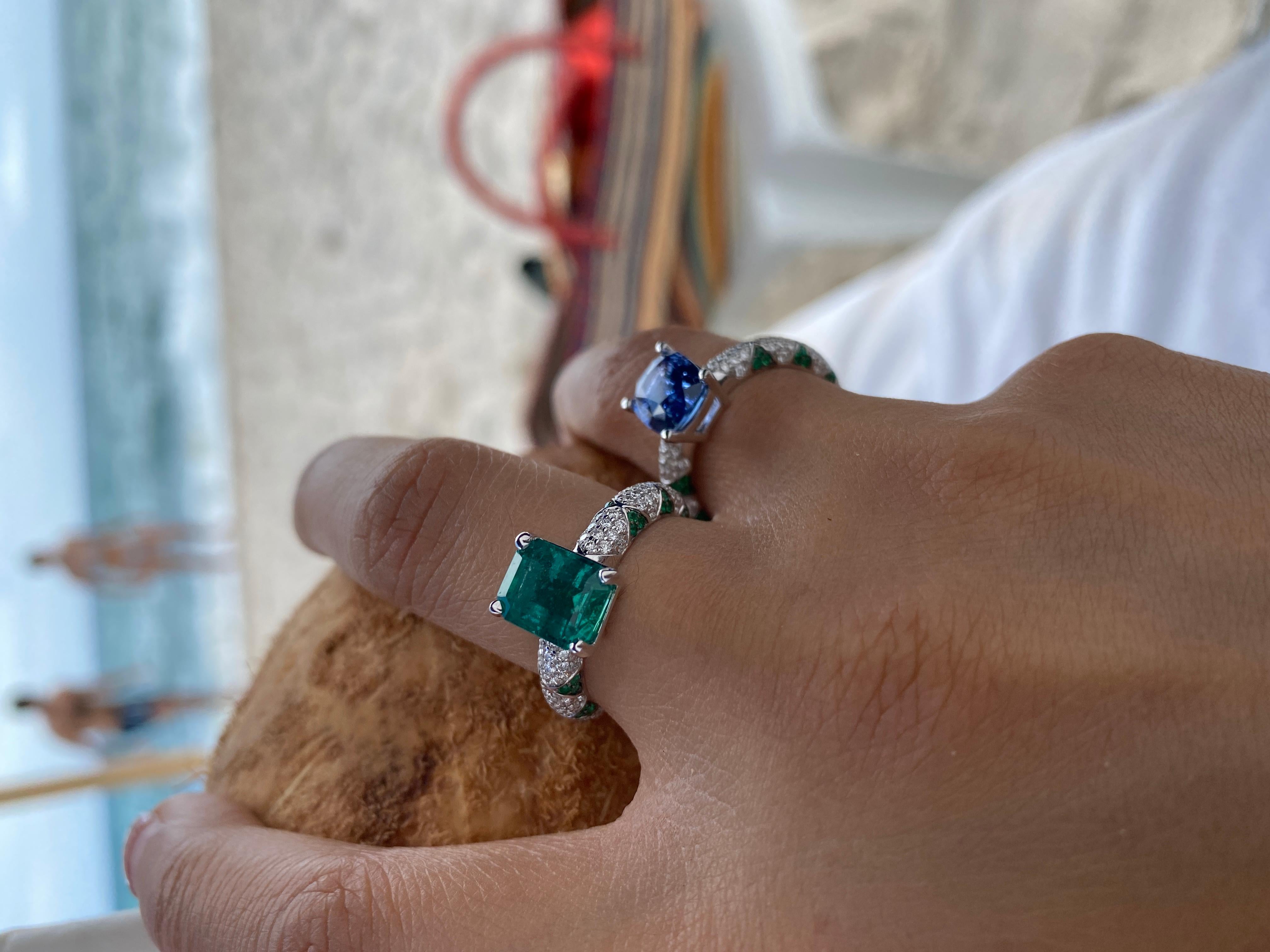 Significant emerald cut Emerald solitaire set in Ri Noor’s iconic lotus motif rings. This statement ring features an emerald solitaire set with emerald petals in a lotus motif and pave set brilliant cut diamonds. Wear it alone as an engagement ring,