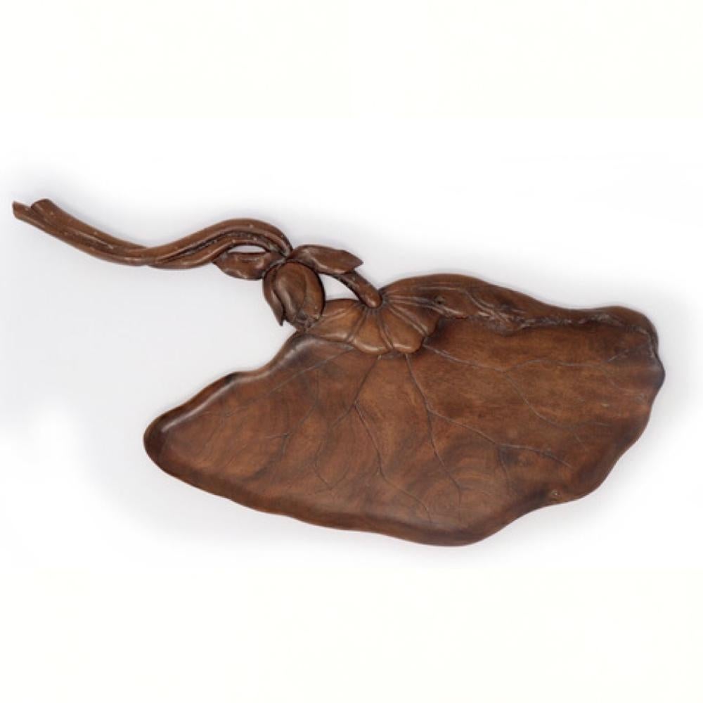 Japanese carved wood tea tray in the shape of a lotus leaf entwined with a lotus blossom stem, carved from one solid piece of kuri (chestnut) elegantly designed with a triangular leaf form and trailing pitted stem covered in a translucent lacquer,