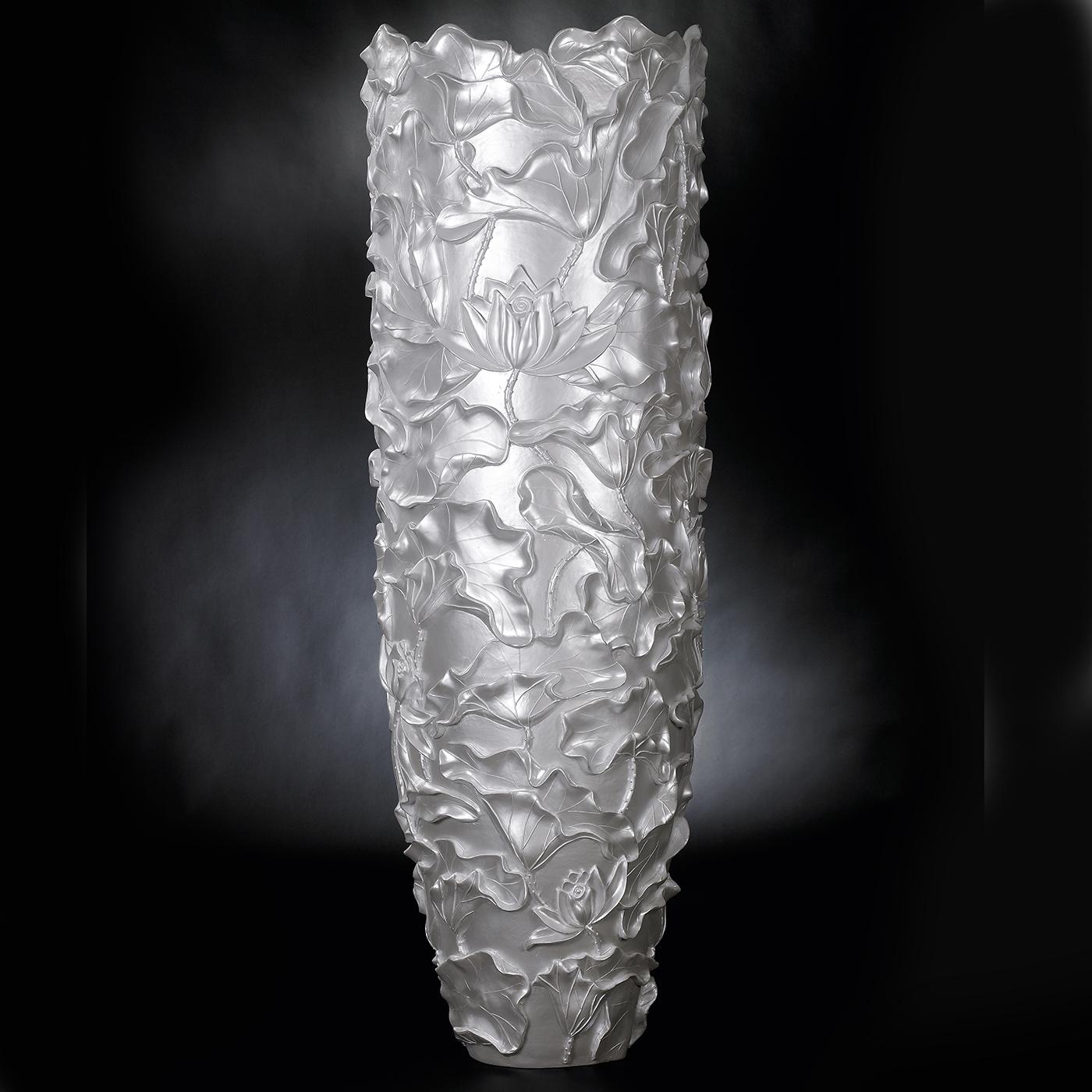 An exquisite combination of the Lotus and the Obice Collections, this vase flaunts the textural decoration of the first one and the tall and clean silhouette of the latter. Handcrafted of resin, it is marked by an iridescent mother of pearl hue that