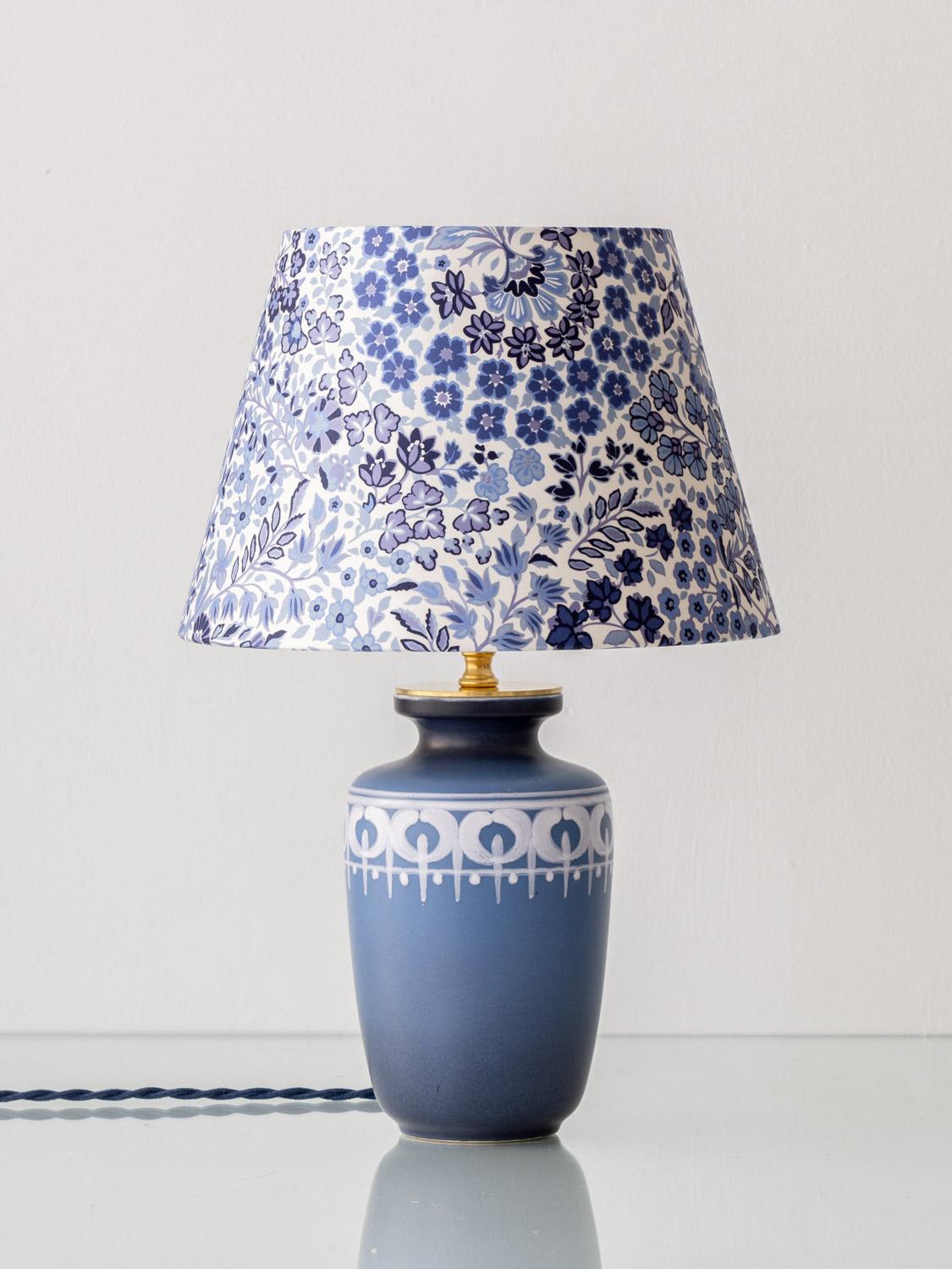 Exquisitely handcrafted by Amitābha Studio in Amsterdam from a rare vintage Flora Gouda vase produced during the short-lived Lotus series in 1977, Lotus is a one-of-a-kind table lamp. The deep indigo vase features a rhythmic band of ivory-toned