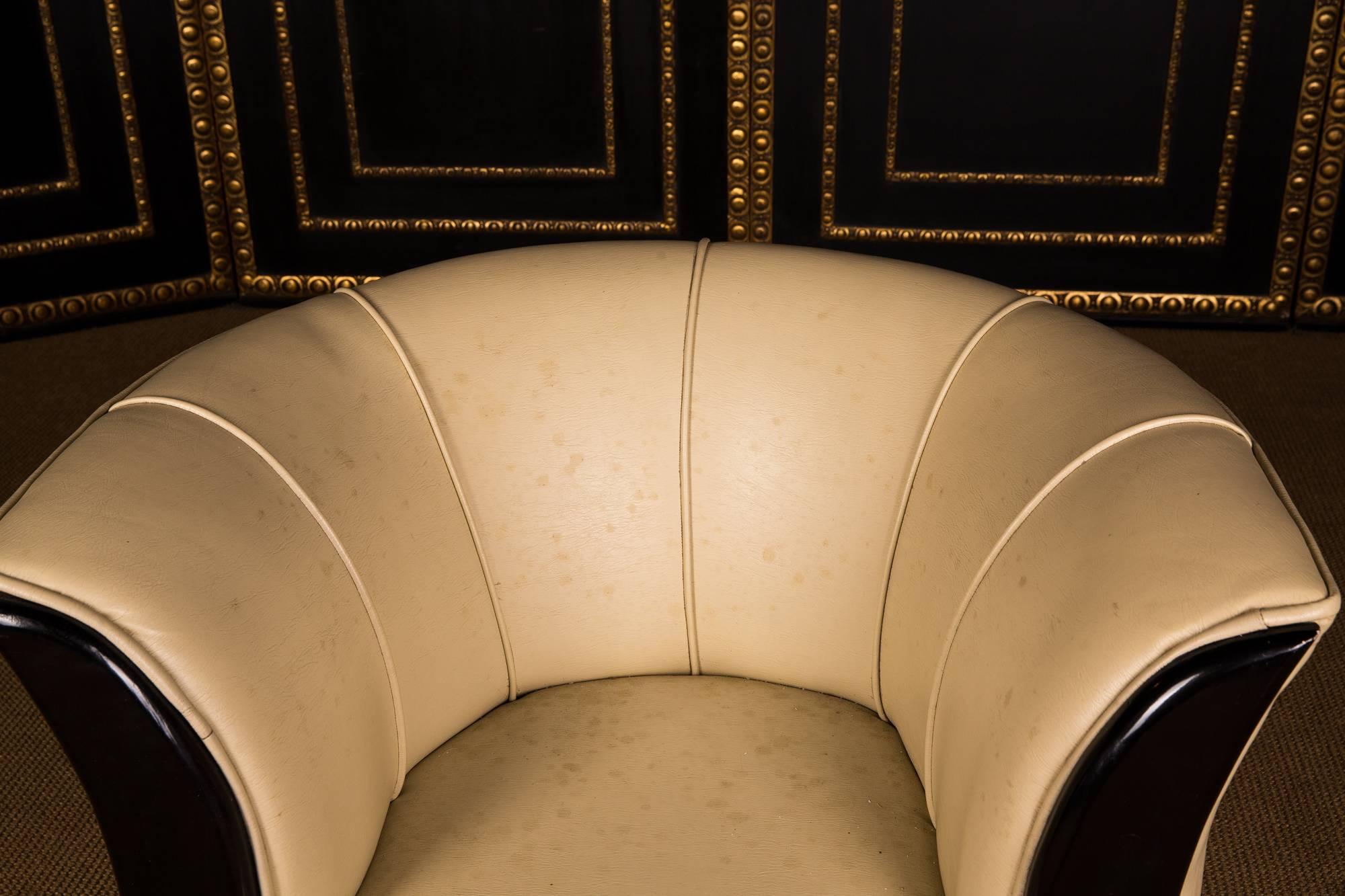 On round black base, high seating flanked by two blackened pointed wooden frames. Backrest leaning backwards. The leatherette is dirty and must be cleaned or changed.