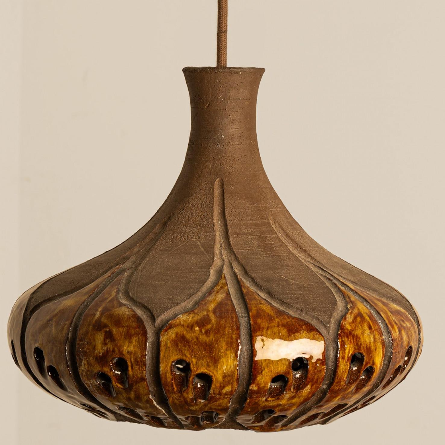 Stylish ceramic pendant light made in Denmark. The lamp is made of orange and brown ceramics and has holes in it, creating a beautiful illumination. The engravings show a pattern of leafs, separating the glazed and rough ceramic.

A unique statement