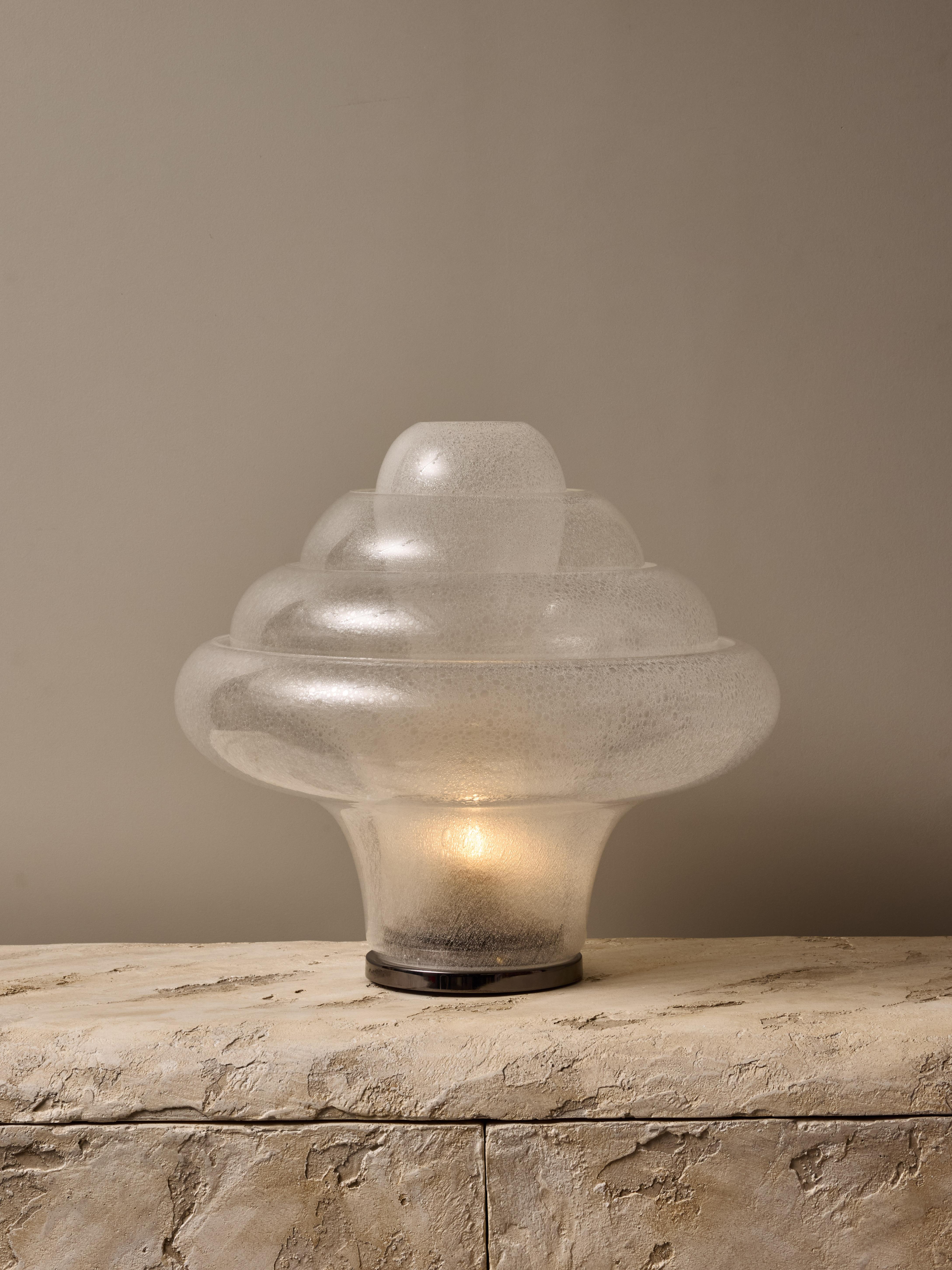Lotus table lamp designed by Carlo Nason and made by Mazzega.

This great example of this mid century Italian classic piece is made of a round metal base, on which are recessed four pieces of blown glass, going higher and narrower with each layer,