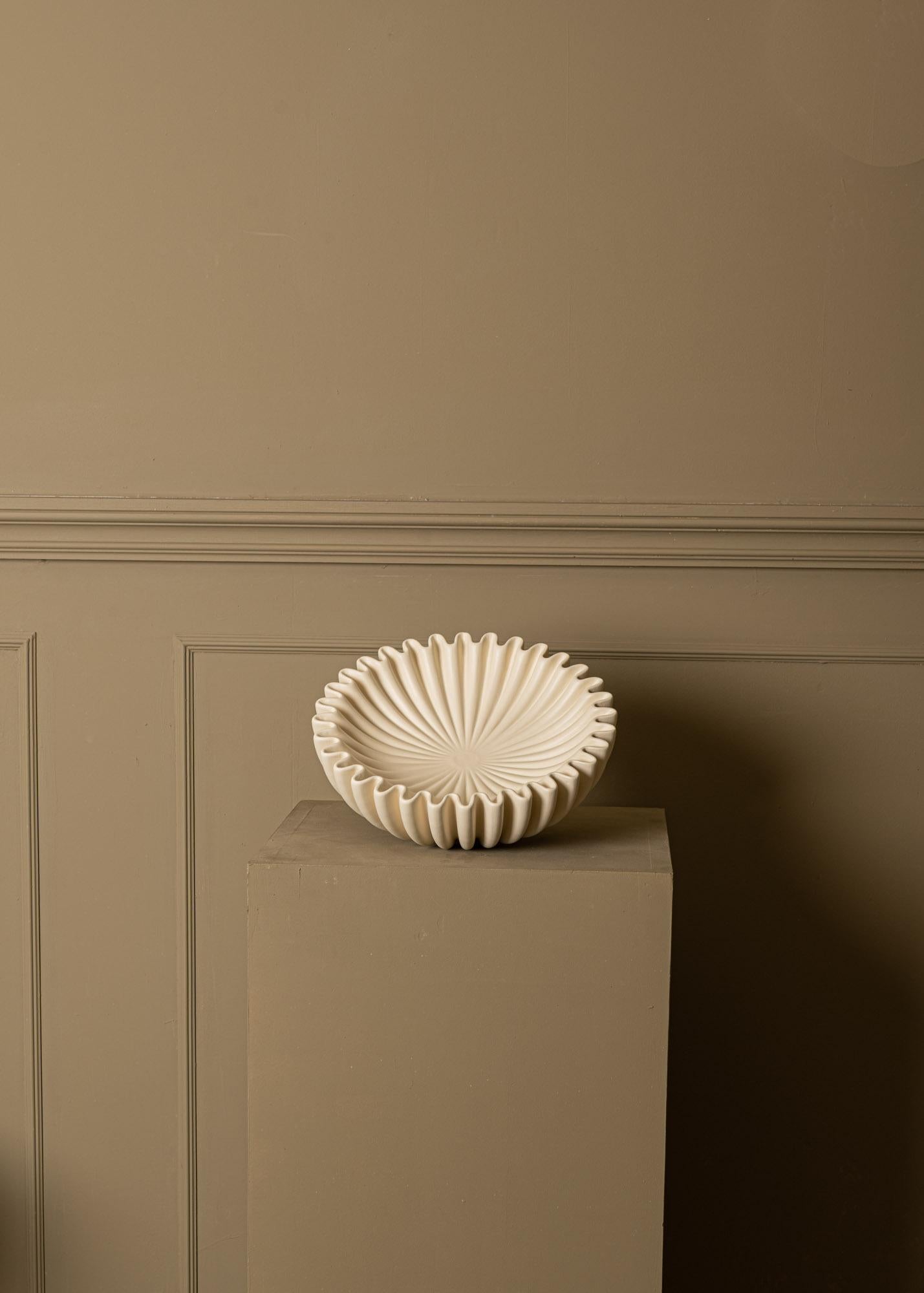 Ein herausragendes Stück Keramik, das durch die kreisförmige Anhäufung von Einlässen zu einem muschelförmigen Objekt wird. Nur eine dekorative Schale.