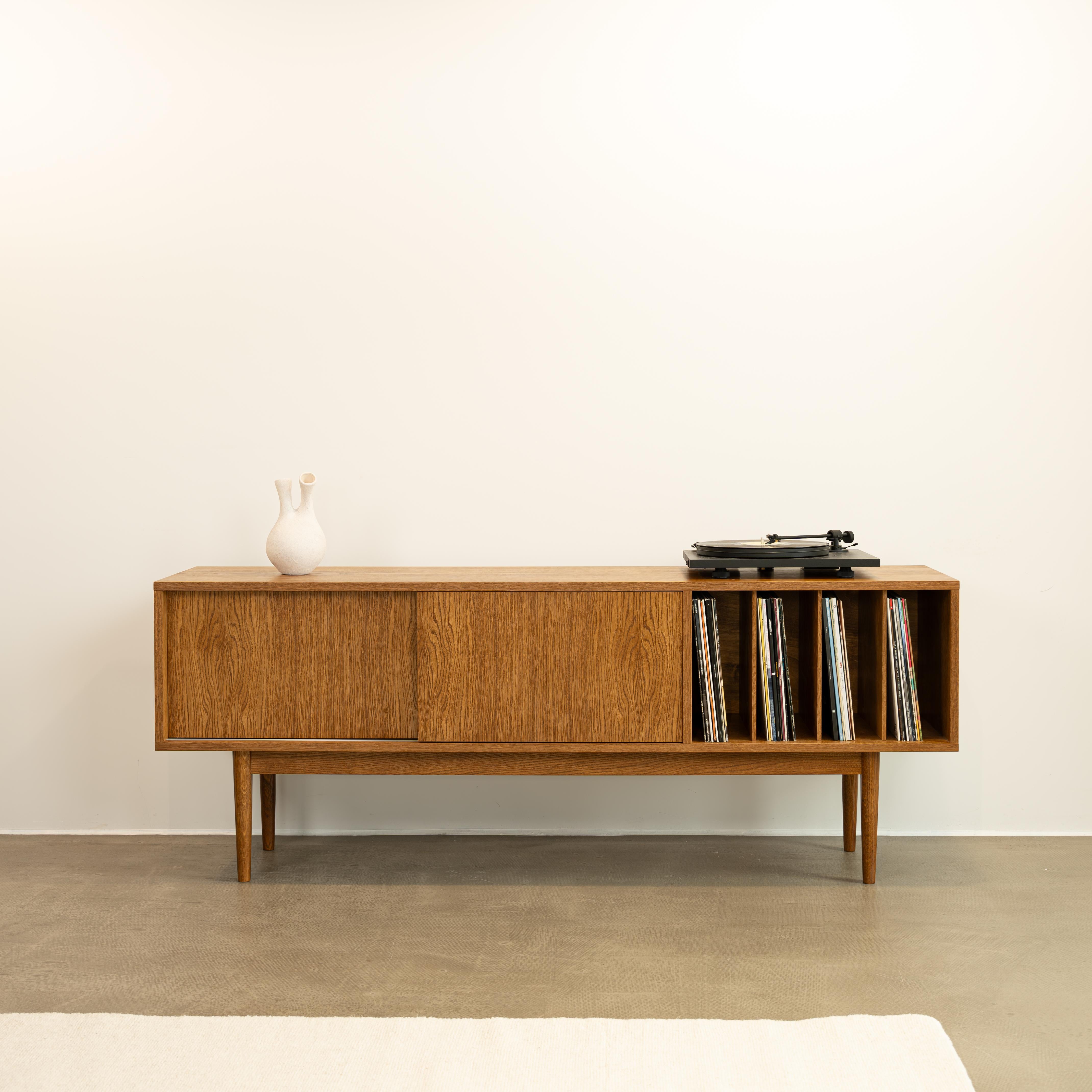 LOTV Vinyl-Schiebeschrank von Pastform
Abmessungen: T 41 x B 150 x H 57 cm
MATERIALIEN: Gebeiztes und lackiertes Holz.

Erhältlich in verschiedenen Holzausführungen: Whiskey, Rum, BPA, Nobel, Brandy, Schwarz, Natura, Nevada, Honig und Cognac.