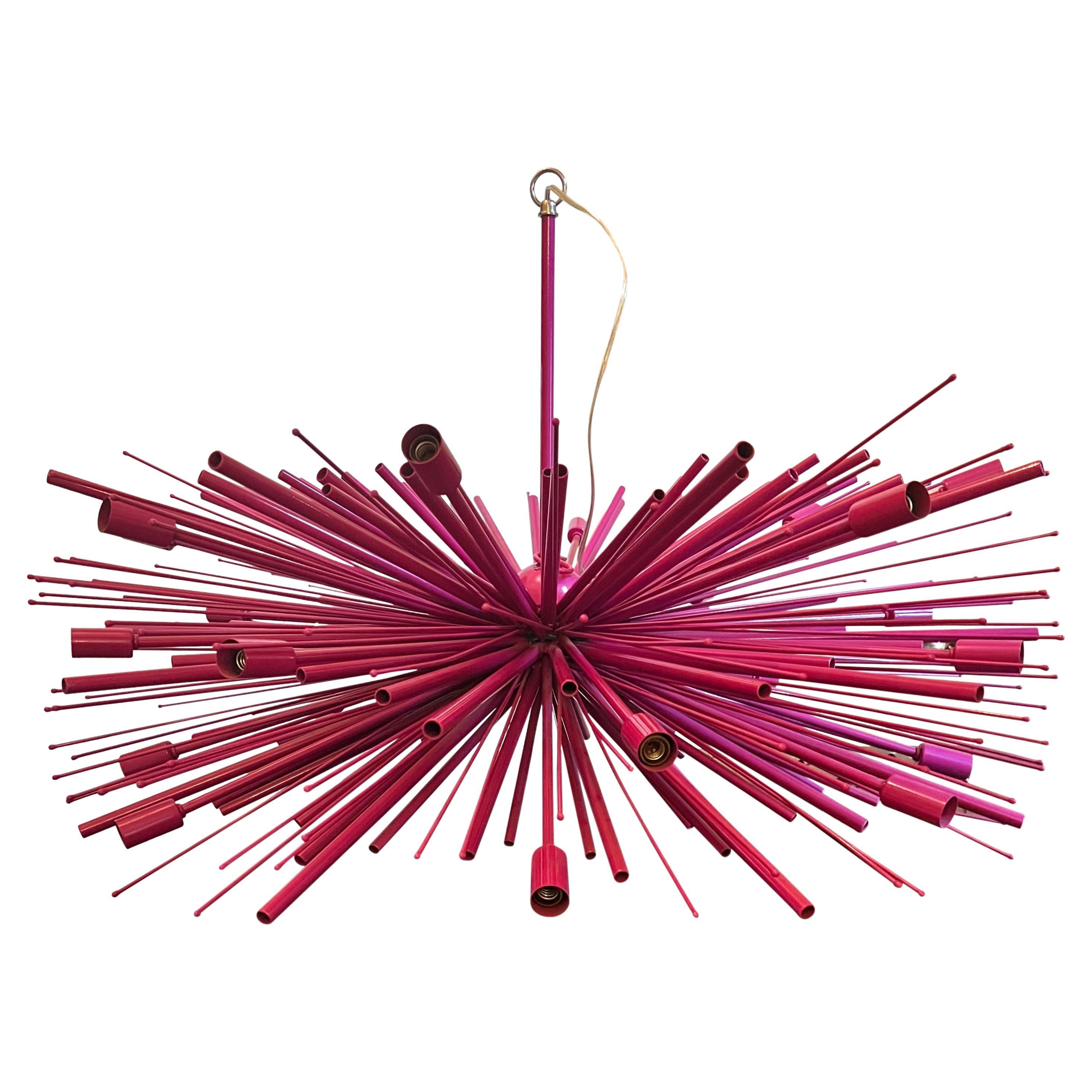 Custom Supernova chandelier in powder-coated steel, original by Lou Blass. Offered in wild fuchsia finish with 24 lights with candelabra bases (maximum of 60 watts per socket). Chandelier is in good working order and comes with a 28