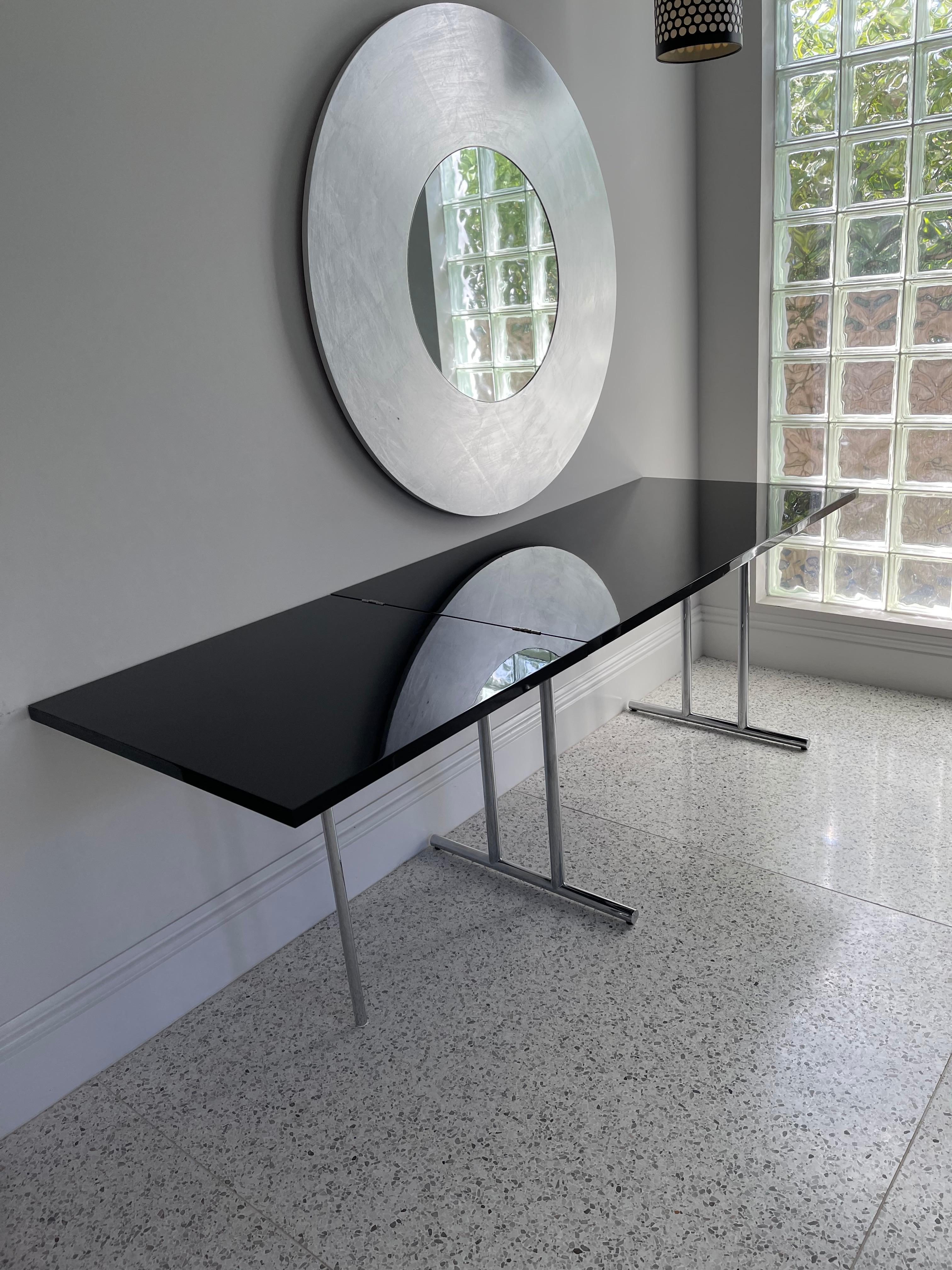 Like the majority of Eileen Gray‘s tables, this one too can transform itself. And as always she found an unexpected solution. The folding section of the tabletop is supported by a single leg out of chrome-plated ubular steel – a conscious break in