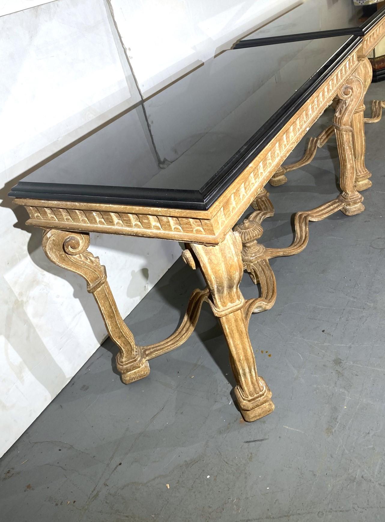 A Louis 14th-style  pair of black marble tops console table.