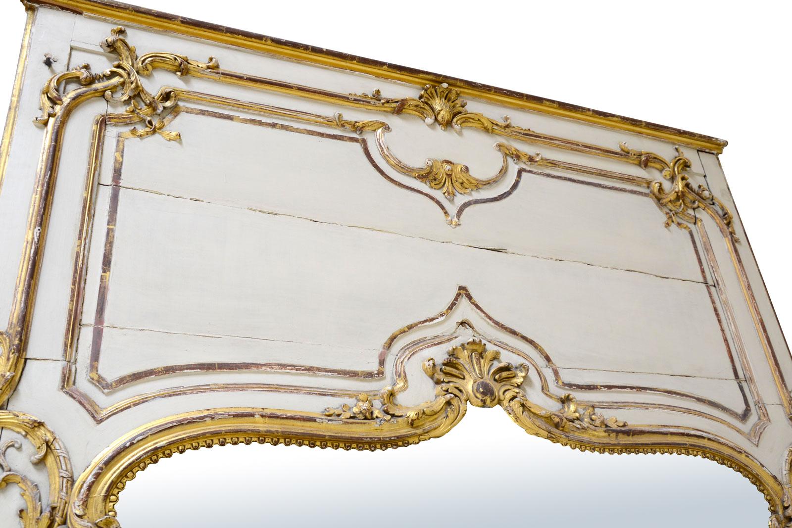Dating from the 19th century, Louis 15 style gilded wood and white rechampi trumeau. It is animated with plants motifs and foliage and a shell overlooks the mirror bordered by a beaded frieze.