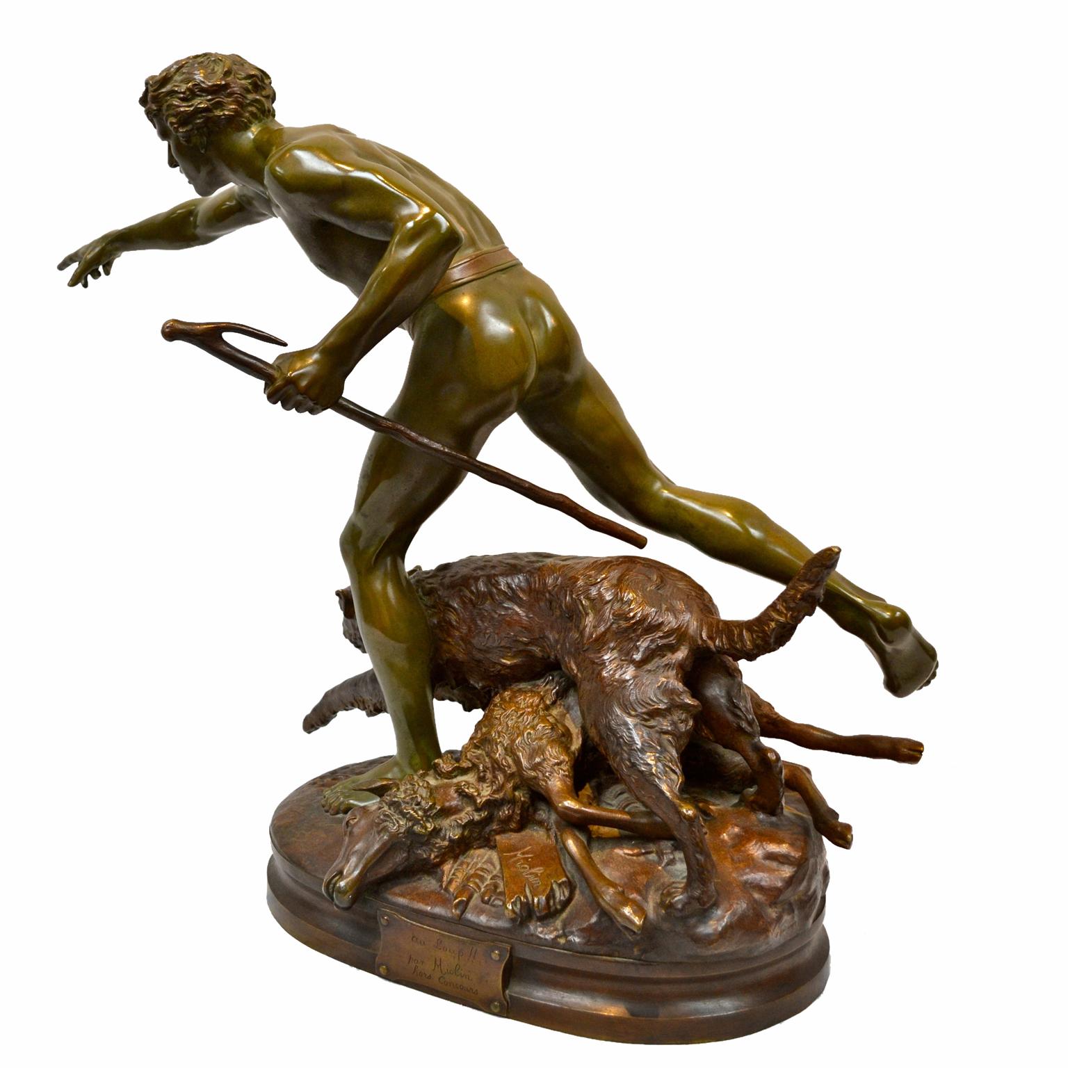 A green patinated figural bronze statue, “Au Loup” (“Chase the Wolf”), by French artist Louis Auguste Hiolin (1846-1912). The sculpture depicts a young shepherd and his dog who, after discovering their fallen lamb, are in pursuit of the unseen wolf