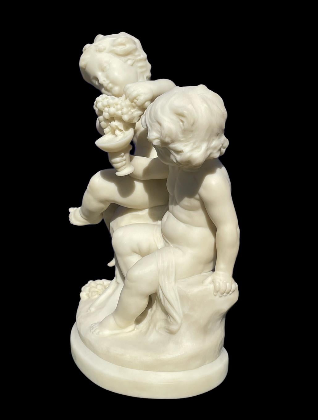 Sculpture en marbre blanc, signée Aug. Moreau, représentant deux putti dégustant des raisins et du vin. La pièce est conforme aux œuvres similaires créées par Auguste Moreau. Cette œuvre particulière est très bien exécutée et en superbe état pour