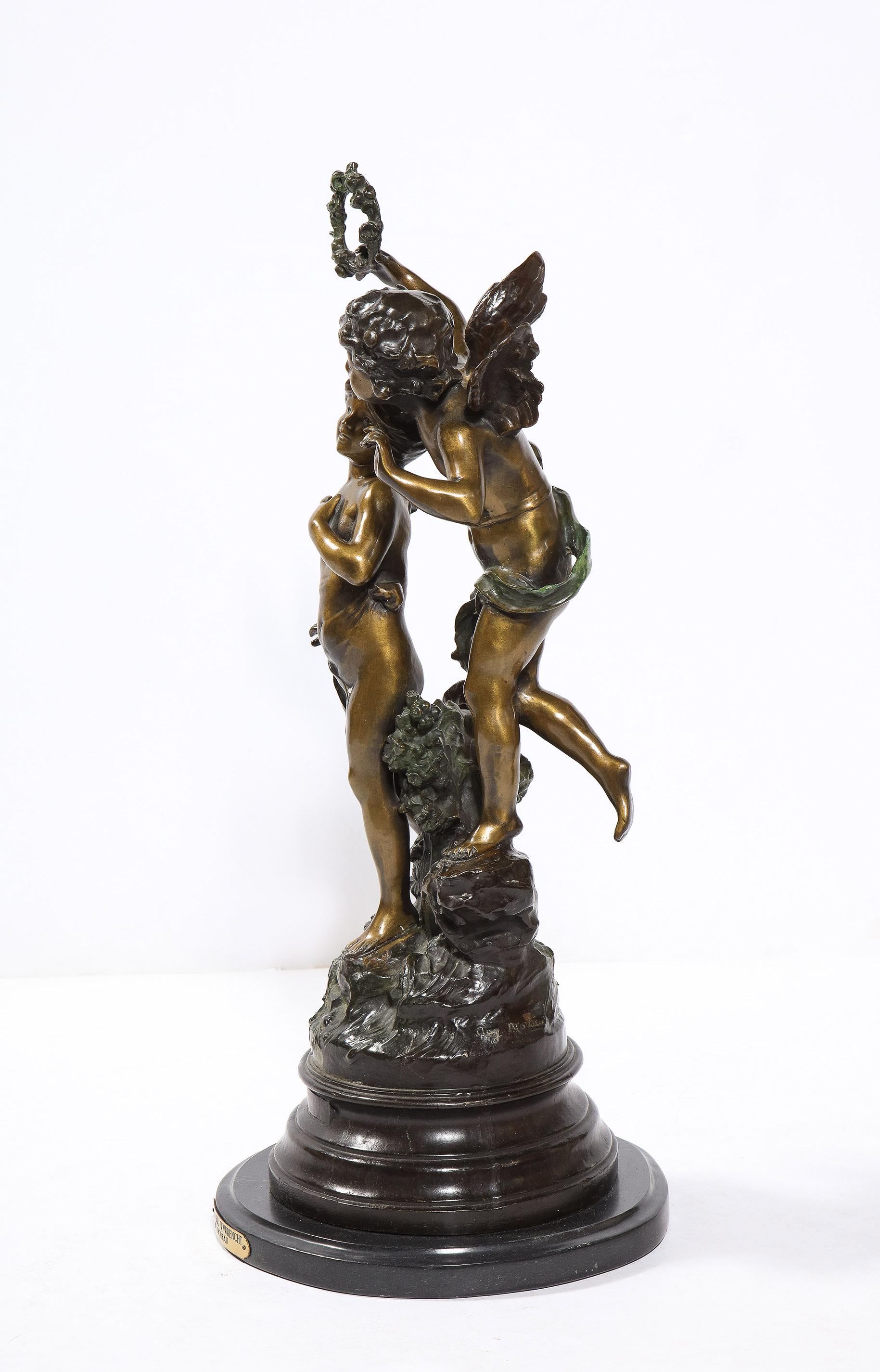 Die Bronzeskulptur mit zwei Patinas von Auguste Moreau zeigt einen geflügelten Jungen mit einem anderen Kind. Auf einem gestuften Sockel aus schwarzem Marmor.
Unterzeichnet AUG. Moreau bei der Besetzung.