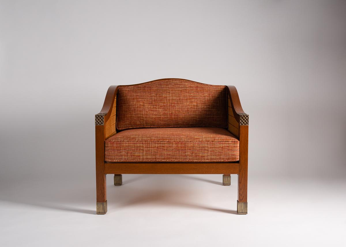 Ces exceptionnelles chaises Louis Cane allient une esthétique traditionnelle à une touche plus contemporaine. Sa base moderne en forme de cube et son dossier perforé sont parfaitement complétés par des accents en bronze patiné et des accoudoirs et