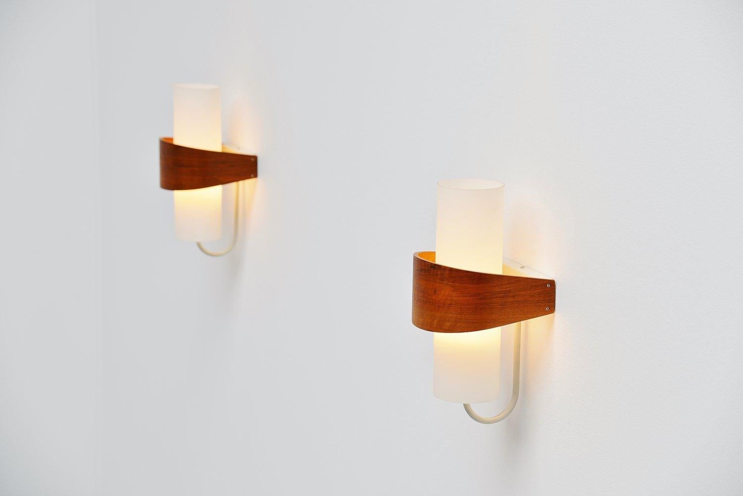 Very nice sconces designed by Belgian designer Louis Christiaan Kalff for Philips, Holland, 1959. These sconces have a very nice combination of materials, teak wood, frosted glass and white lacquered metal. All combined into this beautiful lamp