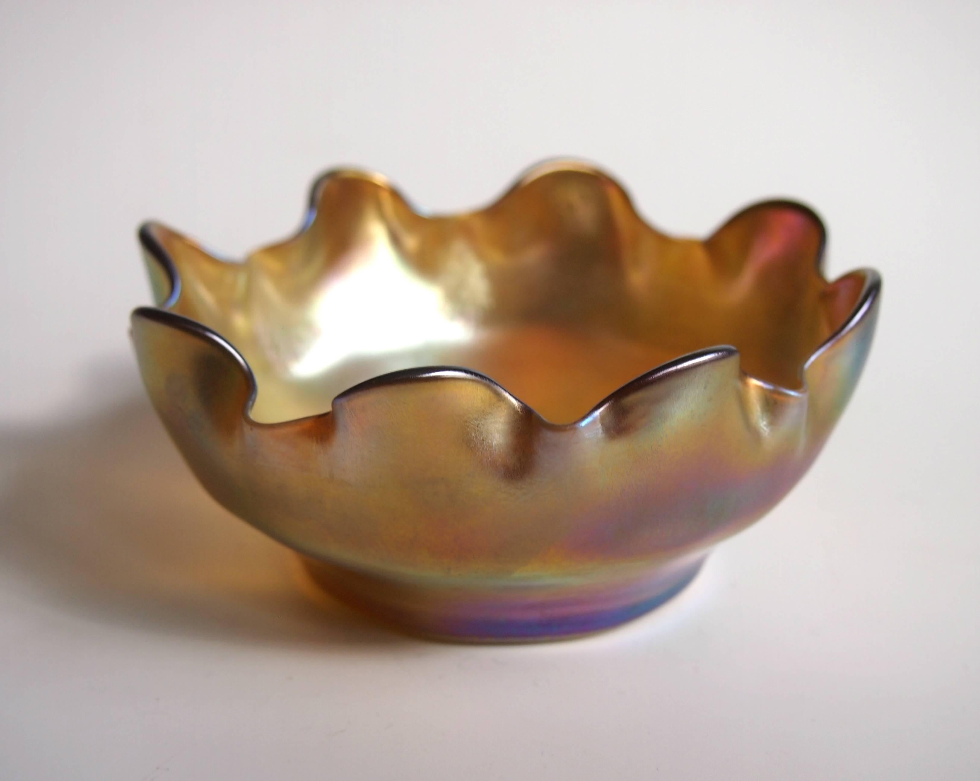 A Fine Art Nouveau Louis comfort Tiffany Favrile finger bowl or dish in the pattern called Queen (Tiffany booklet 1905). It has super light shaded gold with iridescent lustre and highlights of yellow, pink, blue and green. Signed L. C. T. to the