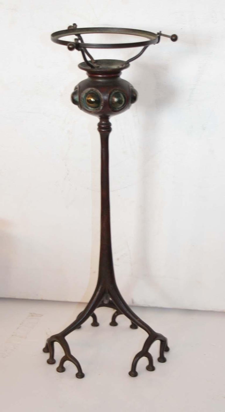 An original signed Louis Comfort Tiffany bronze and glass. Root base with seven individual jeweled glass details. Shade is original and signed, L.C.T. and the base is signed Tiffany Studios New York and numbered 1200. The condition is perfection.