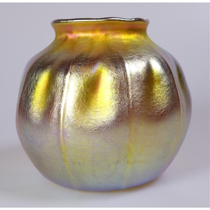 Offering this diminutive Louis Comfort Tiffany gold Favrile iridescent art glass vase. This vase features a ribbed 