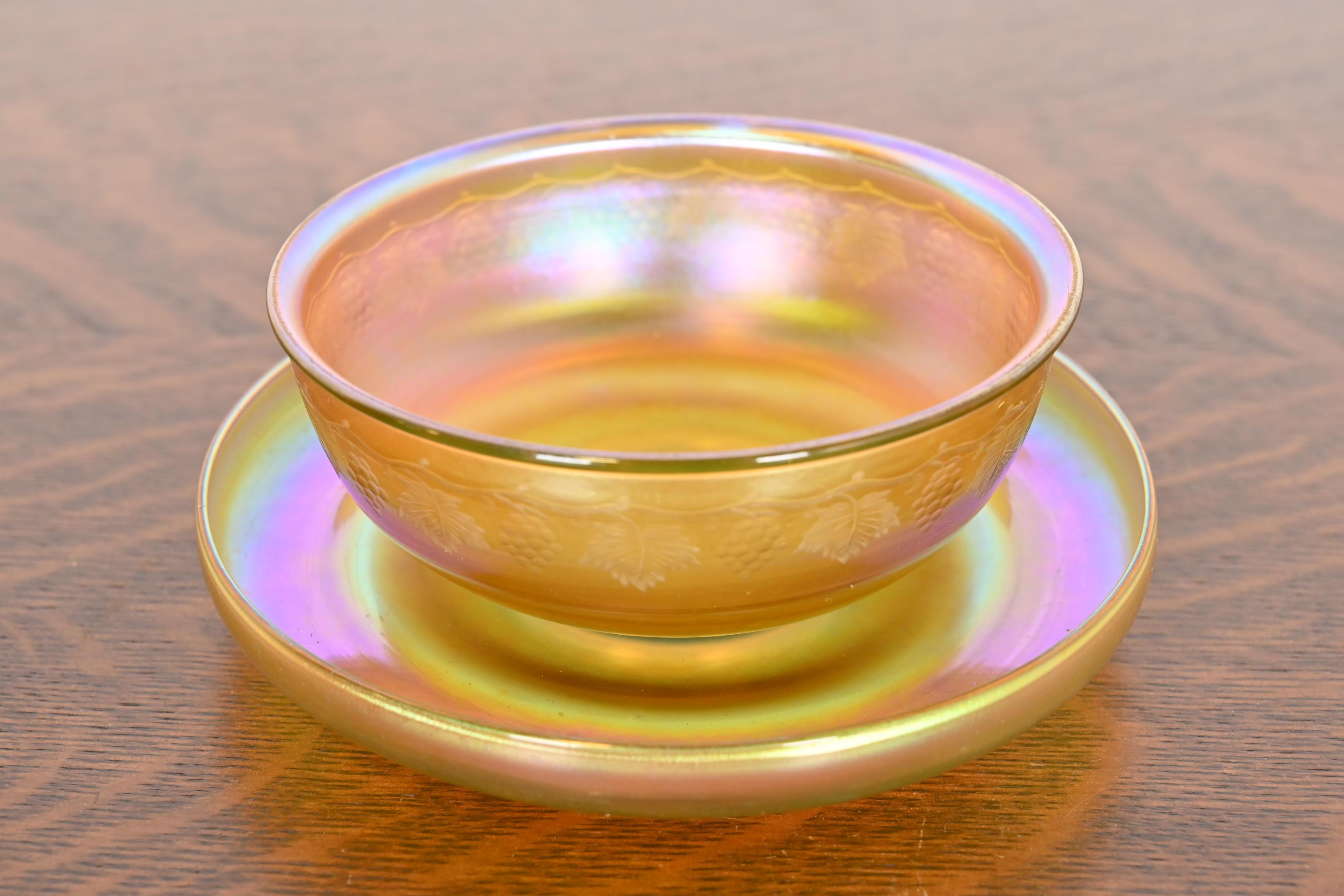 A gorgeous Arts & Crafts or Art Nouveau period Favrile iridescent art glass bowl and underplate with intaglio grapevine motif

By Louis Comfort Tiffany for Tiffany Studios (both pieces signed to the underside)

New York, USA, Circa 1910

Measures: