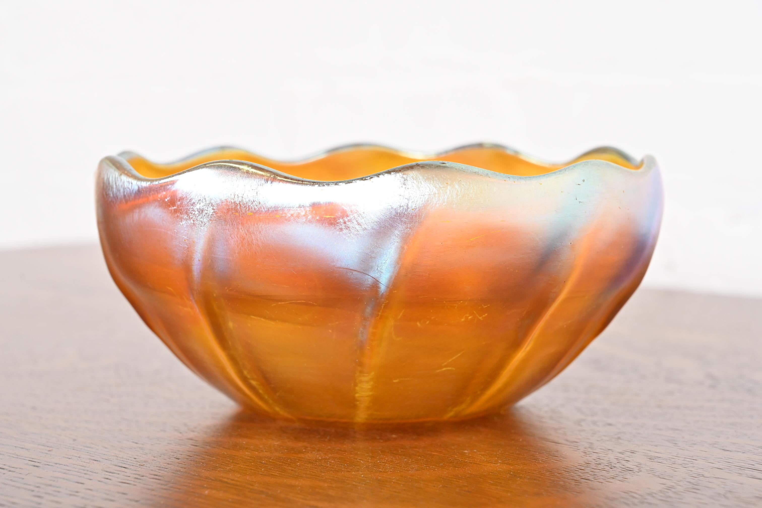 A gorgeous Arts & Crafts or Art Nouveau period Favrile iridescent art glass bowl with scalloped edge

By Louis Comfort Tiffany for Tiffany Studios (signed to the underside)

New York, USA, Circa 1910

Measures: 7.25
