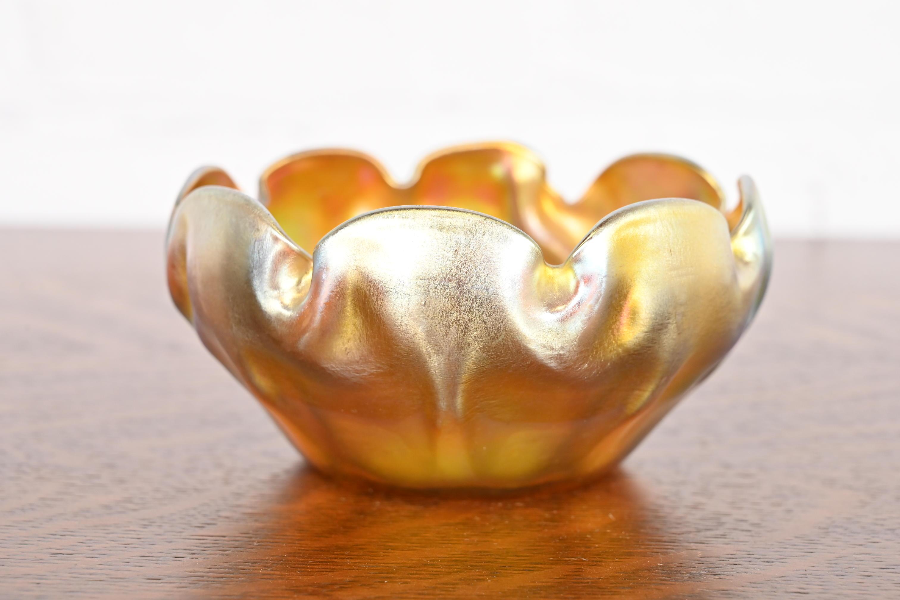 A gorgeous Arts & Crafts or Art Nouveau period Favrile iridescent art glass finger bowl with ruffled edge

By Louis Comfort Tiffany for Tiffany Studios (signed to the underside)

USA, Circa 1910

Measures: 5.25