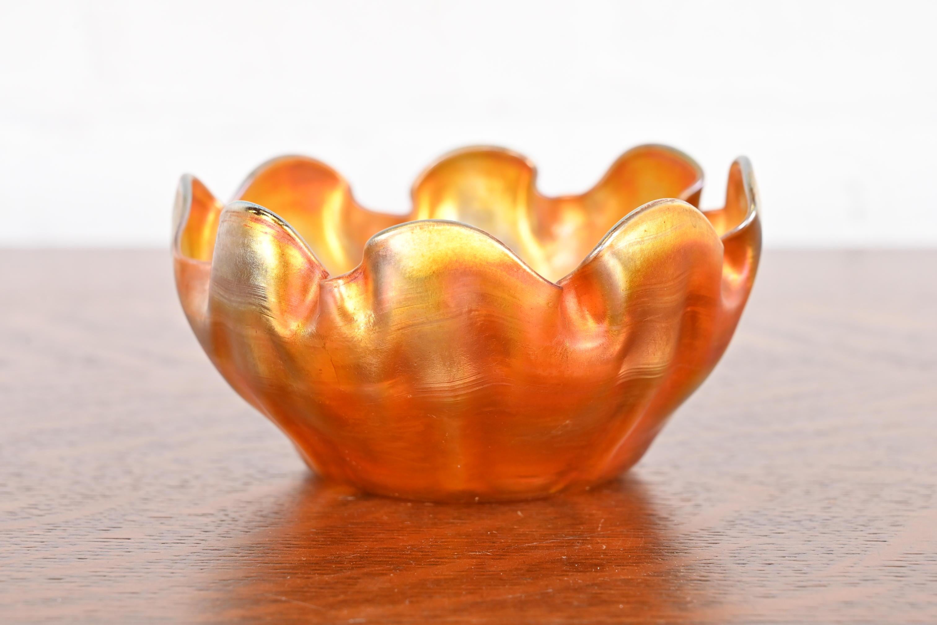 Magnifique coupe à doigt en verre irisé Favrile d'époque Arts & Crafts ou Art Nouveau, avec un bord volanté.

Par Louis Comfort Tiffany pour Tiffany Studios (signé au-dessous)

États-Unis, vers 1910

Mesures : 4,75 