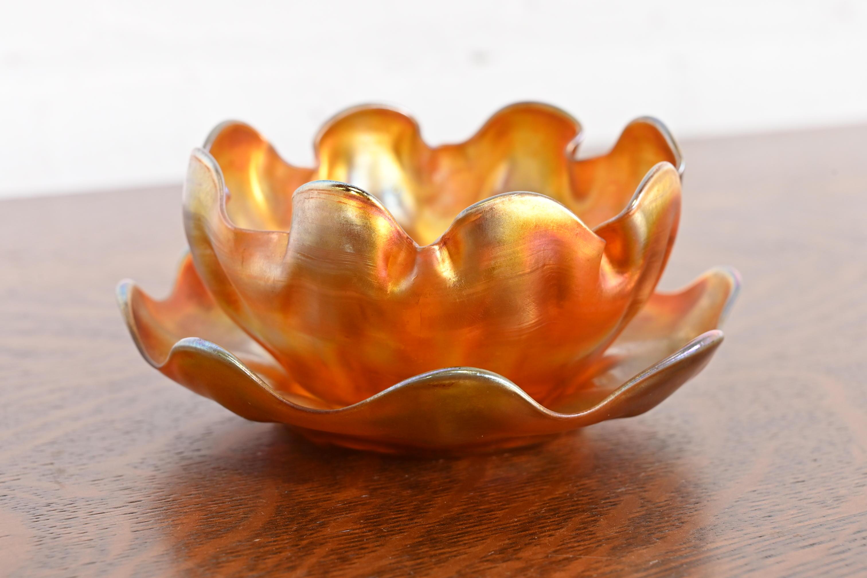 Magnifique coupe à doigt en verre irisé Favrile d'époque Arts & Crafts ou Art Nouveau, avec sous-plat.

Par Louis Comfort Tiffany pour Tiffany Studios (les deux pièces sont signées sur la face inférieure)

États-Unis, vers 1910

Mesures :
Bol : 4,75