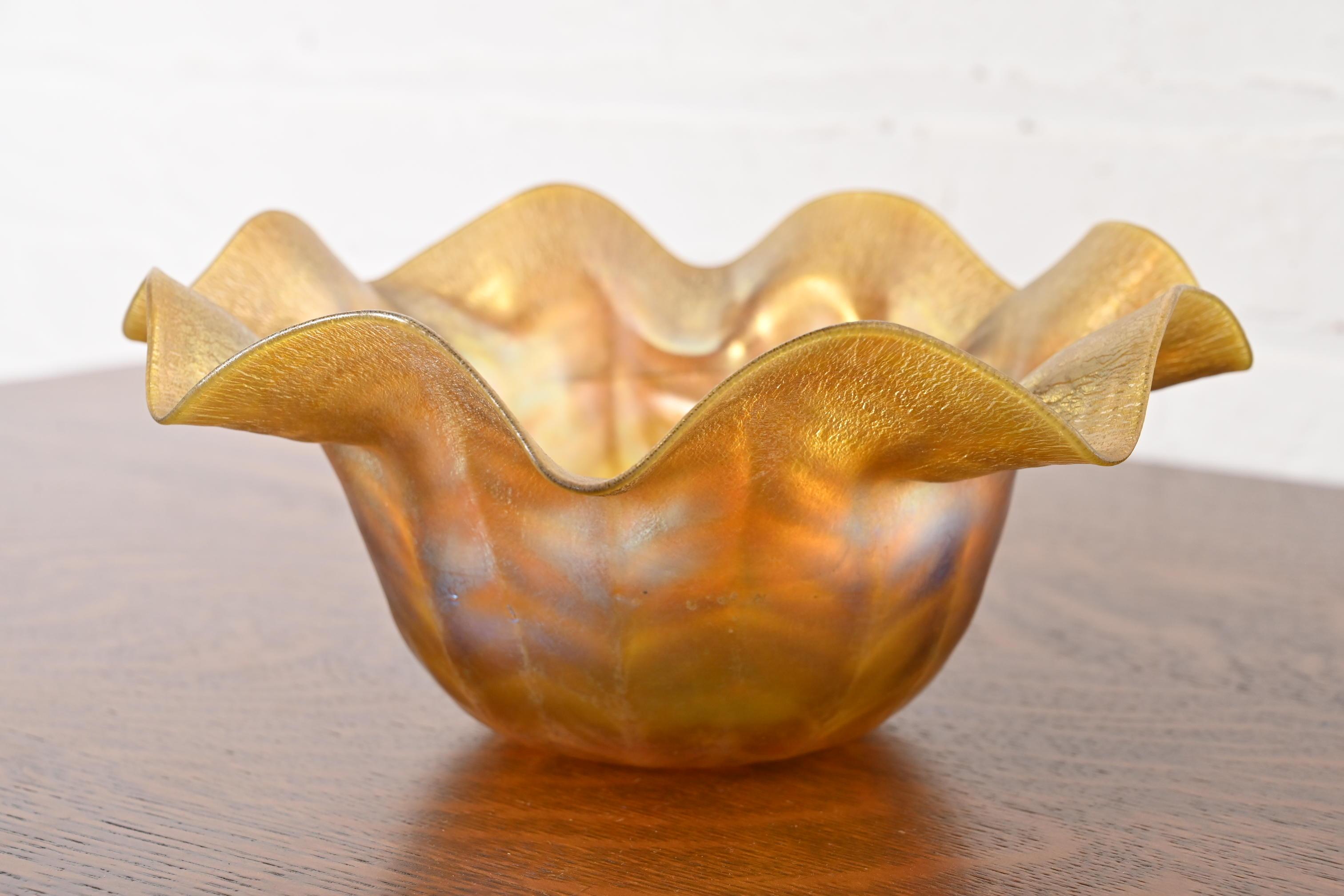 Una splendida ciotola floriforme in vetro artistico Favrile iridescente del periodo Arts & Crafts o Art Nouveau con bordo svasato e increspato.

Di Louis Comfort Tiffany per Tiffany Studios (firmato sul lato inferiore)

USA, circa 1910

Misure: