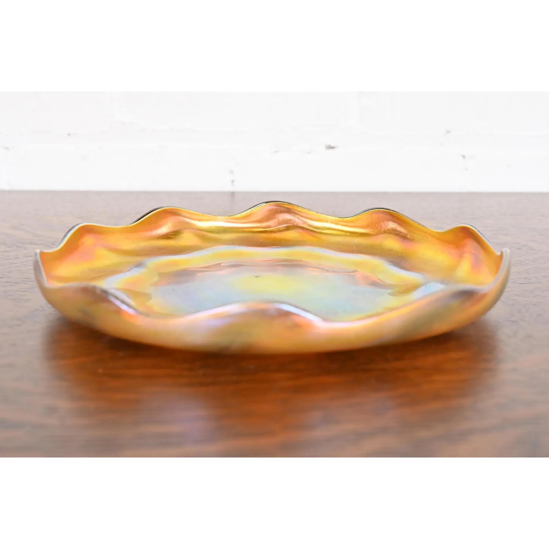Precioso plato o bandeja de vidrio artístico iridiscente Favrile de la época Arts & Crafts o Art Nouveau con borde festoneado

Por Louis Comfort Tiffany para Tiffany Studios (firmado en la parte inferior)

Nueva York, EE.UU., circa 1910

Medidas: 9
