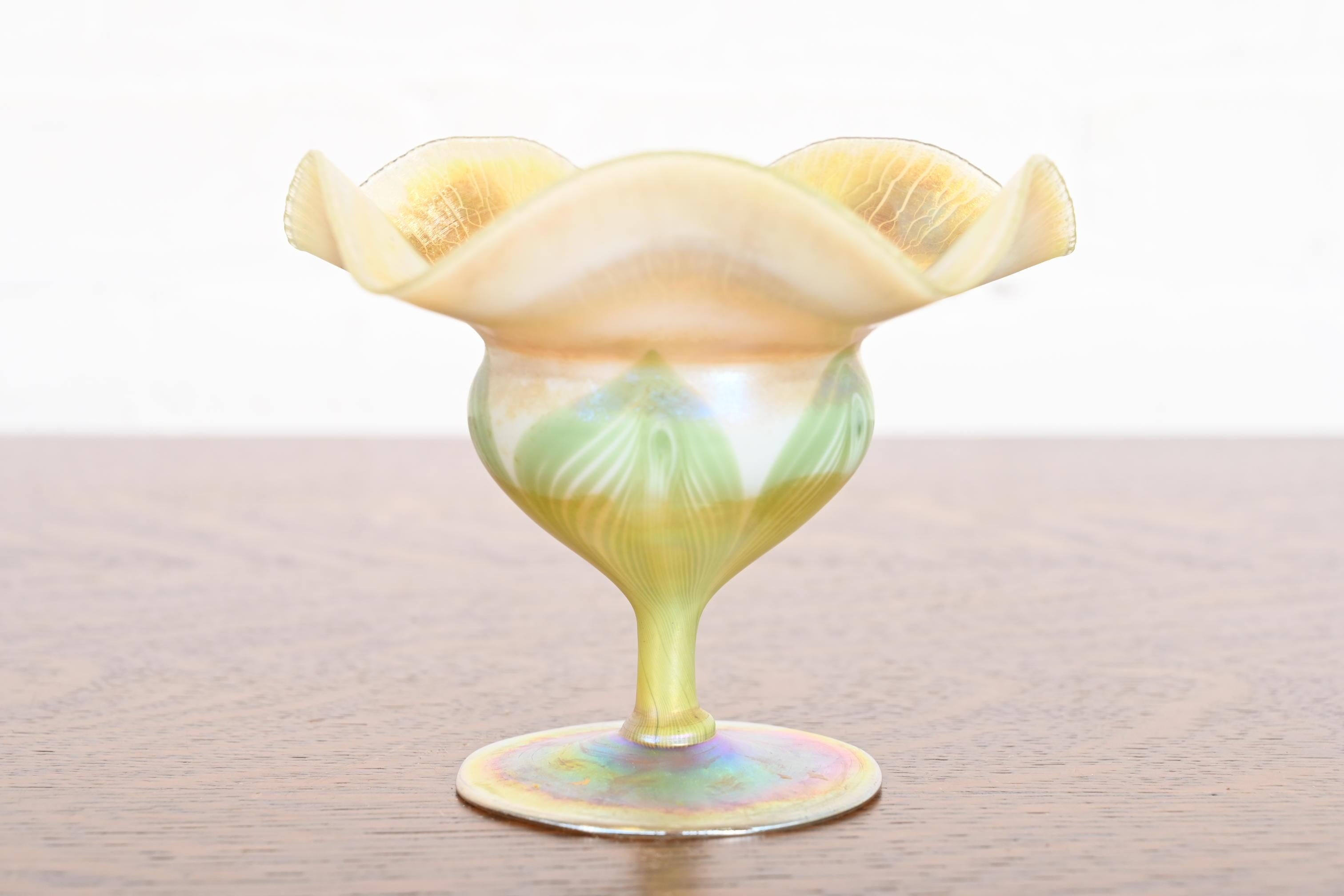 A gorgeous Arts & Crafts or Art Nouveau period Favrile iridescent art glass footed bowl or compote dish with ruffled edge and pulled feather design.

By Louis Comfort Tiffany for Tiffany Studios (signed to the underside)

USA, Circa 1910

Measures:
