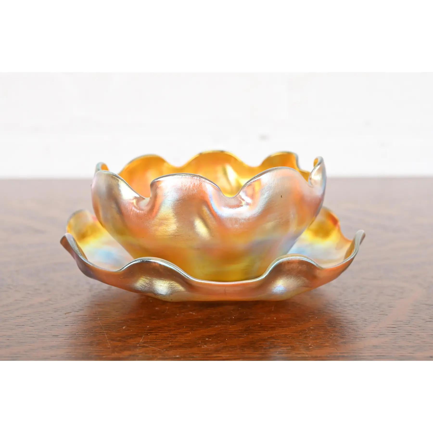 Magnifique coupe à doigt en verre irisé Favrile d'époque Arts & Crafts ou Art Nouveau, avec sous-plat.

Par Louis Comfort Tiffany pour Tiffany Studios (les deux pièces sont signées sur la face inférieure)

États-Unis, vers 1910

Mesures :
Bol : 4,75