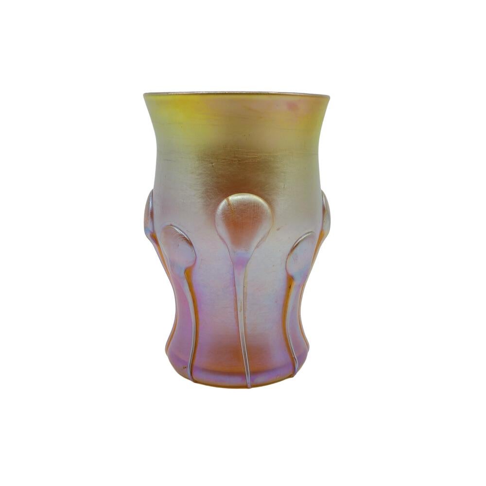Offering this diminutive Louis Comfort Tiffany gold Favrile iridescent art glass cordial glass that may also be used as a toothpick holder / shot glass. This cordial features a rounded, cinched body with 