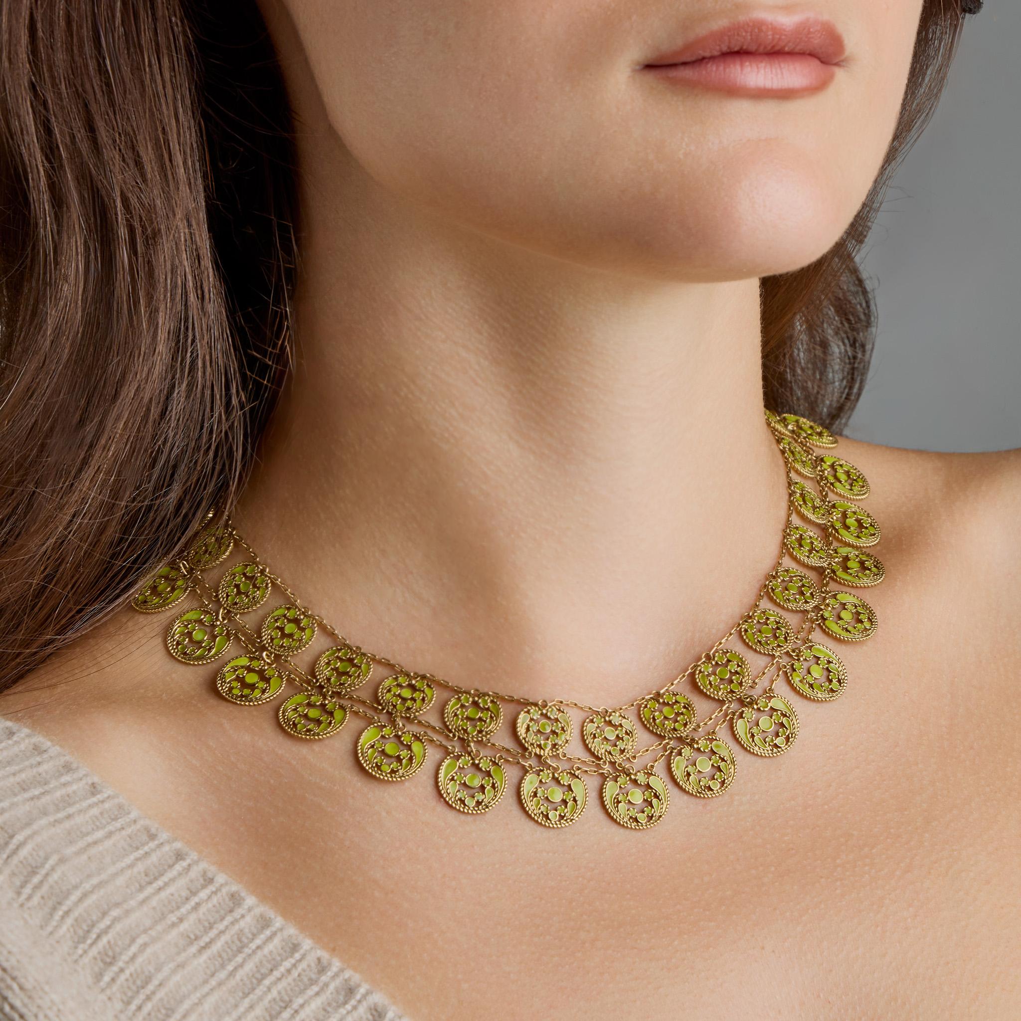 Created circa 1910 by Louis Comfort Tiffany of Tiffany & Co. with the collaboration of Julia Munson, this necklace is formed of 18K gold and plique-à-jour enamel. It is designed as a double row of circular twisted filigree elements of stylized