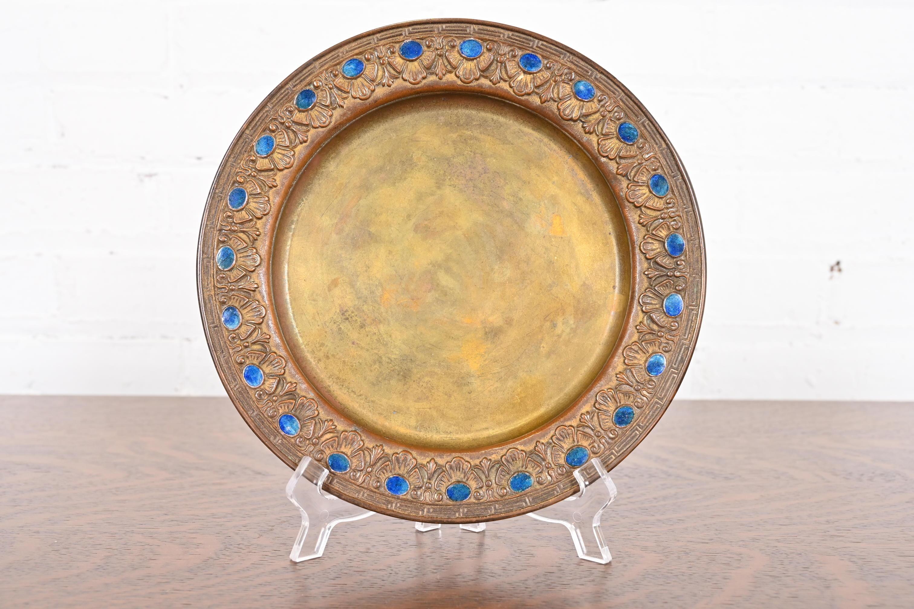 Ein prächtiger vergoldeter Bronzeteller aus der Zeit des Arts & Crafts oder Art Deco mit emaillierter Juwelenverzierung

Von Louis Comfort Tiffany Furnaces Inc. (signiert auf der Unterseite)

New York, USA, 1920er Jahre

Maße: 8,25 