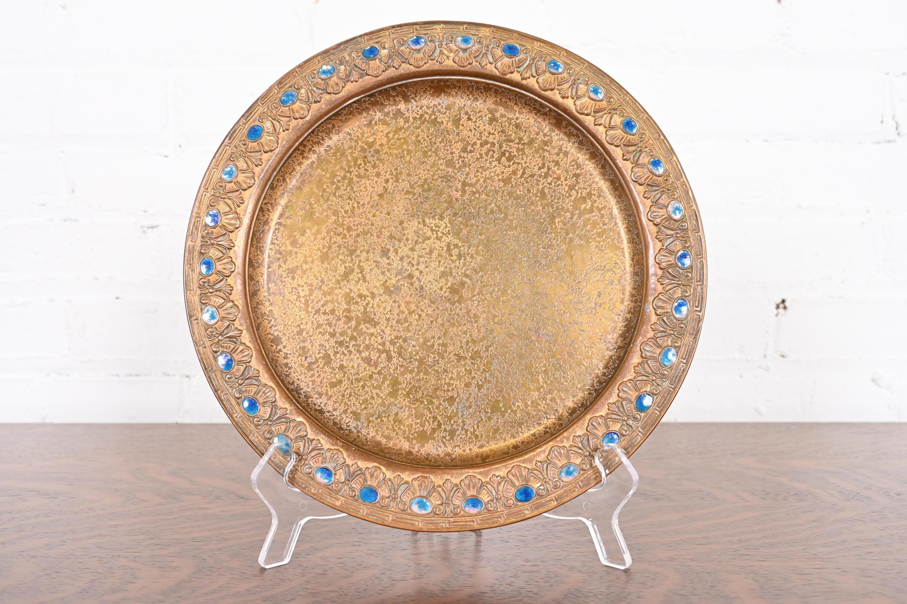 Un magnifique plateau de charge en bronze doré d'époque Arts & Crafts ou Art Deco avec une décoration de bijoux émaillés.

Par Louis Comfort Tiffany Furnaces Inc. (signé au-dessous)

New York, États-Unis, années 1920

Dimensions : 10,13 