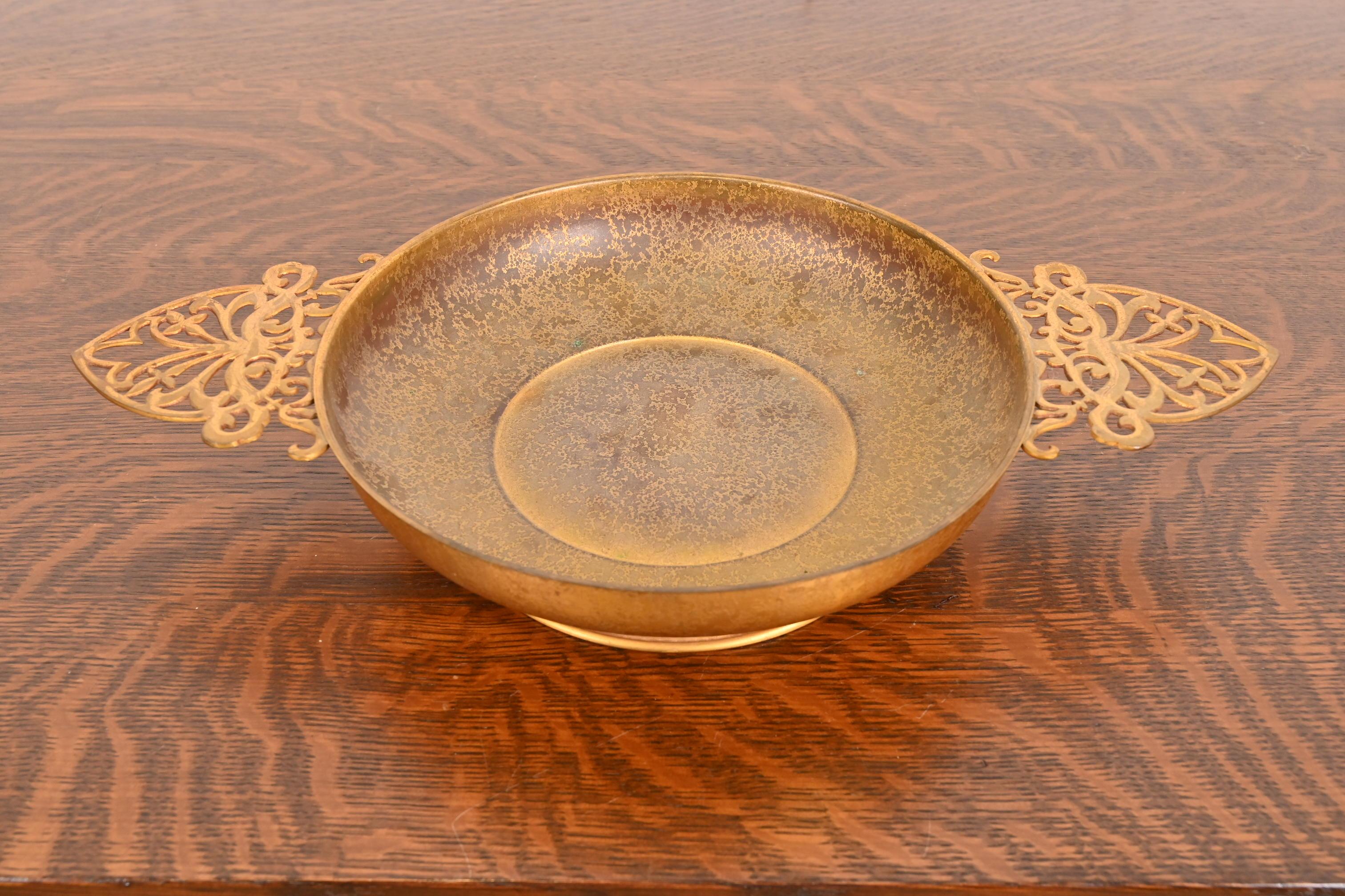 Una splendida ciotola da centrotavola con piede in bronzo dorato del periodo Arts & Crafts o Art Deco con manici

Di Louis Comfort Tiffany Furnaces Inc. (firmato sul lato inferiore)

New York, USA, anni '20

Misure: 18 