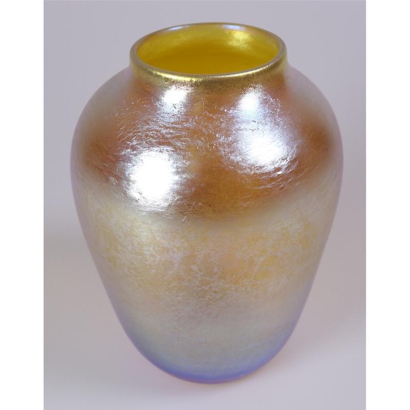 Offering this diminutive Louis Comfort Tiffany gold Favrile iridescent art glass vase. This vase features a tapered cylindrical body with smaller flared lip. Signed on the underneath 