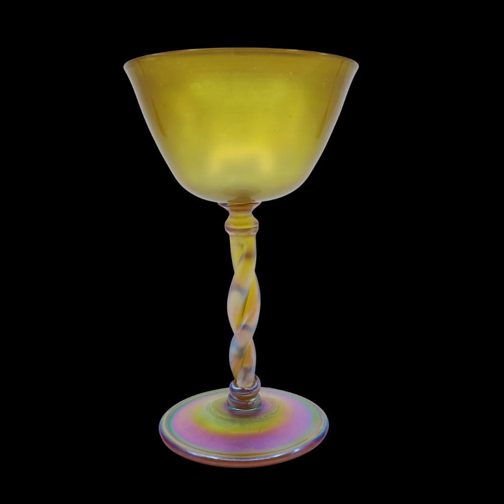 Offering this diminutive Louis Comfort Tiffany gold Favrile iridescent art glass stem goblet. This goblet features a tapered vessel with a double twisted rod stem design and applied round foot. Signed on the underneath 