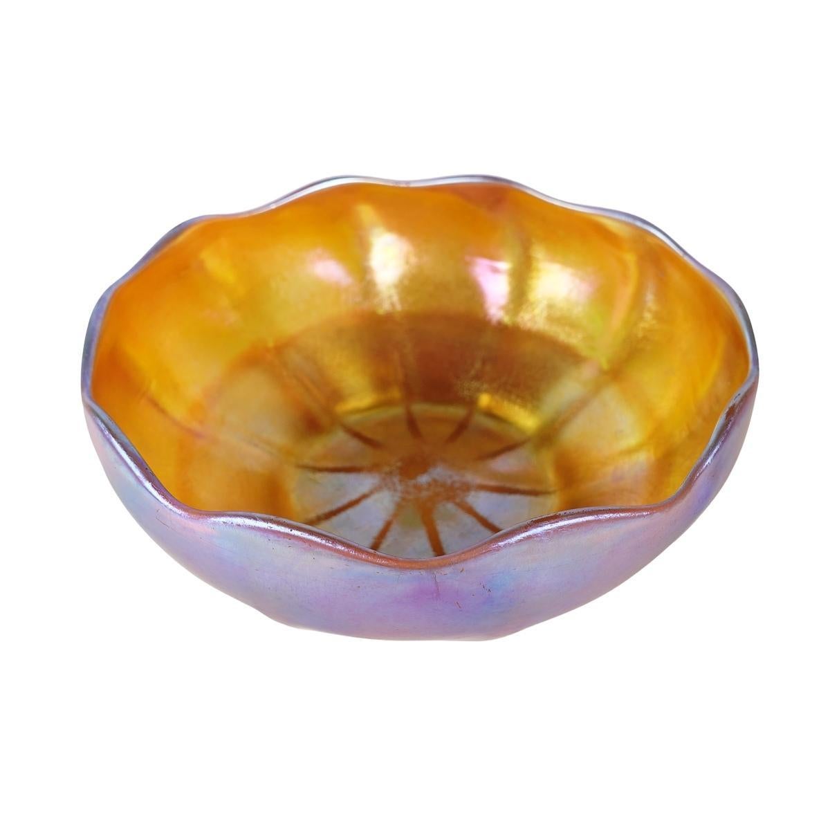 Offering this nice size Louis Comfort Tiffany gold Favrile iridescent art glass serving bowl. This 