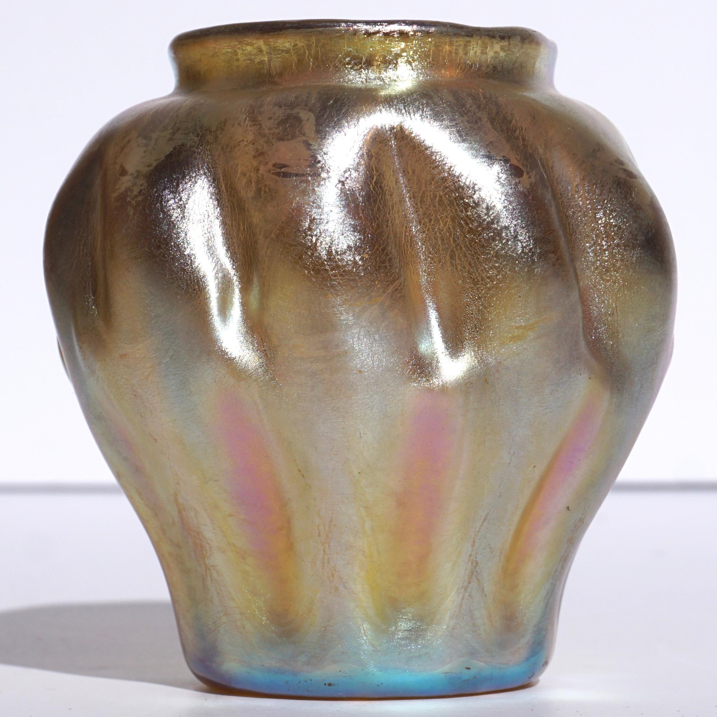 A great Tiffany favrile gold cabinet vase with beautiful pink and glue iridescence. The globular decorated pinched design screams Art Nouveau and was probably made circa 1895.

Engraved signature: “L.C.Tiffany Favrile 5406E”

Measures: Height